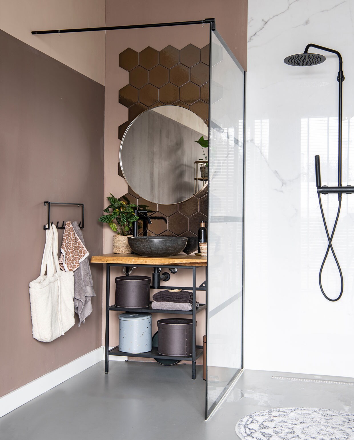 Gietvloer Evolve, marmeren douchewand Jan Groen, spiegel Light &amp; Living, kraan, waskom en douchewand herkomst onbekend, kapstok Woood, tas Zara, handdoeken Walra, tegels Marktplaats, behang Eijffinger, badmat HKliving, blik Ferm Living, dozen Ikea.
