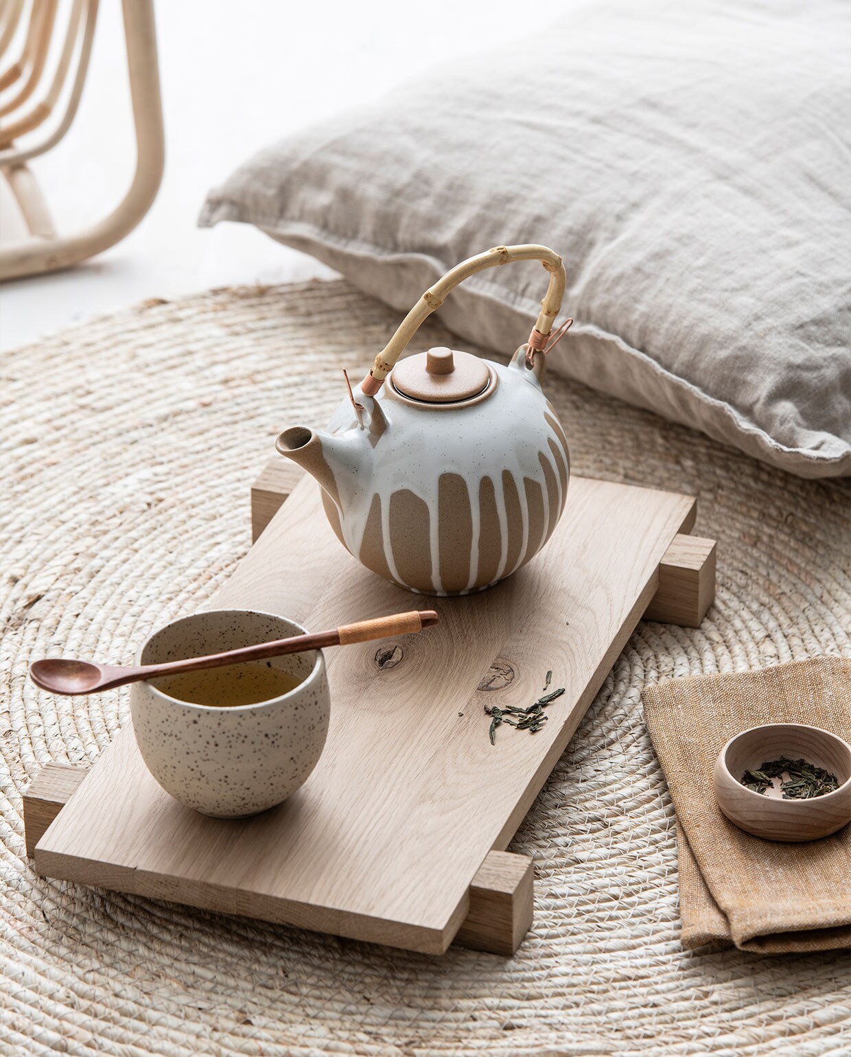 Handgemaakte gespikkelde aardewerken mok € 16,95 (ohmyhome.nl). Handgemaakte Japanse houten lepel € 4,50 (petitdepot.nl). Rieten vloerkleed € 14,99 (xenos.nl). Rotan tijdschriftenhouder Buskbo € 17,95 (ikea.nl). Terracotta theepot Camellia van Bloomingville € 29,95 (livvlifestyle.nl). Gewassen linnen kussenhoes € 9,99 (hm.com). Overig privébezit.