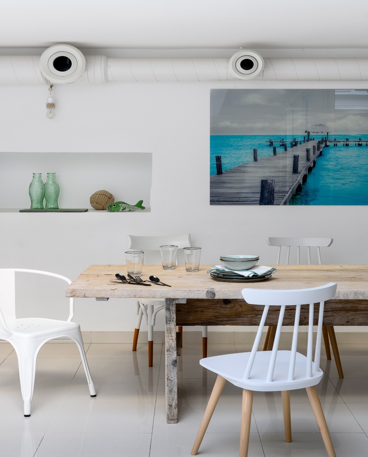 Tegen de schutting plantte Kim sterjasmijn, die je zelfs binnen ruikt. Witte rotan bank Sika Design. Geel-zwarte plaid van de stof Fujin Jaune van Pierre Frey. Kussens o.a. Designers Guild, West Elm en gemaakt van stoffen Sampan Stripe en Tunis Daisy van Jim Thompson. Witte bijzettafel Block &amp; Chisel. Grijze plantenpot Habitat. Buitenkleed Pappelina. Overig onbekend.