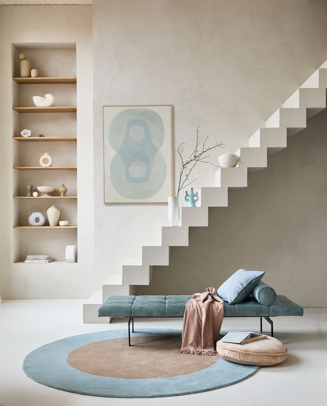 Op de muur kalkverf Fresco Old Flax van Pure &amp; Original, per liter € 55,- (paint-pure.nl). Daybed Alfies in Faded Blue, 190x70x38 cm (bxdxh) vanaf € 828,- (versmissen.nl). Schilderij Longing for, acryl op canvas van Anne Olde Kalter, 70×100 cm prijs op aanvraag (anneoldekalter.com). Rond vloerkleed Dot, 200 cm (Ø) € 699,- (festamsterdam.com). Rond fluwelen zitkussen van HKliving, 60 cm (Ø) € 55,99. Vaas Shell Pot van Ferm Living € 99,-, vaas Forma large van Bolia € 90,- (vtwonen.nl). Lichtblauwe kandelaar van &amp;Klevering € 35,- (groenenakker.nl). Witte kom op trap € 39,99 (zarahome.com). Vazen met bol erop op bovenste plank prijs op aanvraag (byjoa.nl). Witte vaas cirkel € 14,99 (hm.com). Vaas van 101CPH op tweede plank € 39,- (debijenkorf.nl). Schaal op voet € 59,95 (urbannatureculture.nl). Overig privébezit.