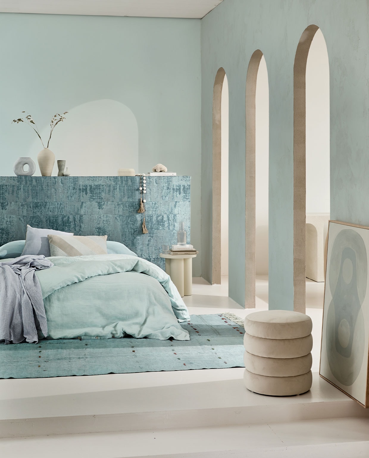 Behang Atelier d’Artiste Brumes Existentielles VP 880 23 van Elitis, per rol van 1×10 m € 241,- (elitis.fr). Linnen dekbedovertrek Pale Blue, 220×240 cm € 325,-, linnen laken Scandinavian Blue, 320×270 cm € 235,-, katoenen sprei Sky Blue, 140×220 cm € 139,-, lichtblauwe handgeknoopte hennep kelim, 291×184 cm € 1095,- (couleurlocale.eu). Fluwelen poef Alto, 42×47 cm € 99,- (westwingnow.nl). Kruk Noo.ma Oly in Piazza Beige € 289,-, lichtblauwe vaas van HKliving € 32,30, lichtblauw gestreept kussen, 40×60 cm van HKliving € 30,60, sierkussen Outline van Hay in Ice Blue € 55,99, karaf Ripple van Ferm Living € 39,- en glazen Ripple van Ferm Living, set van 4 € 35,- (vtwonen.nl). Schilderij Longing for, acryl op canvas van Anne Olde Kalter, 70×100 cm prijs op aanvraag (anneoldekalter.com). Op de muur krijtverf Estate Emulsion Skylight 205 van Farrow &amp; Ball, 2,5 liter € 97,- (paint-paper.nl). Overig privébezit.