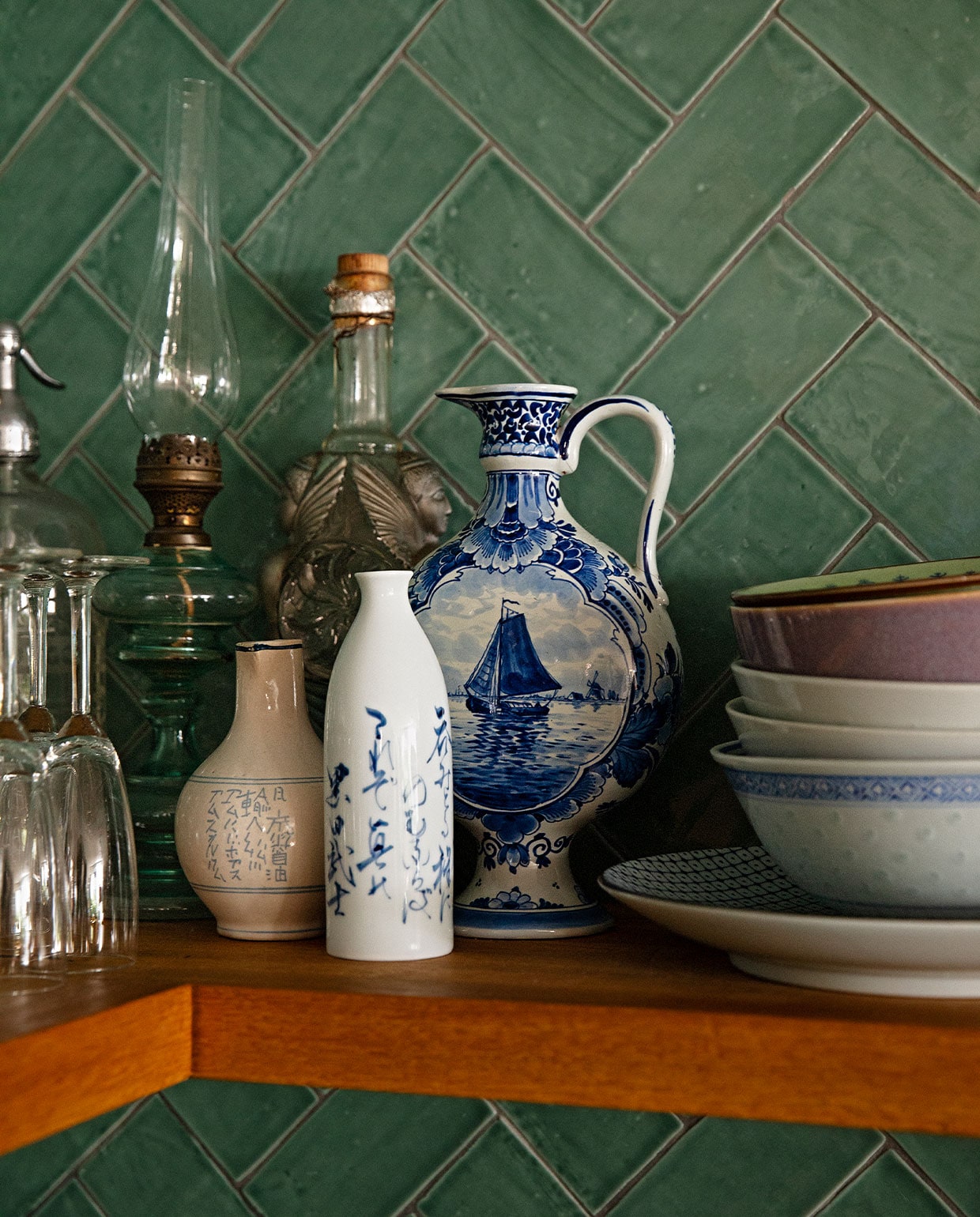 Handgevormde donkergroene tegels Metrotegel, champagneglazen gekregen, olielamp, vaasje, karaf, hoge fles erfstuk, set decoratie overblijfsel van een fotoshoot, borden en kommetjes verzameling van Aziatische winkels in New York en Amsterdam.