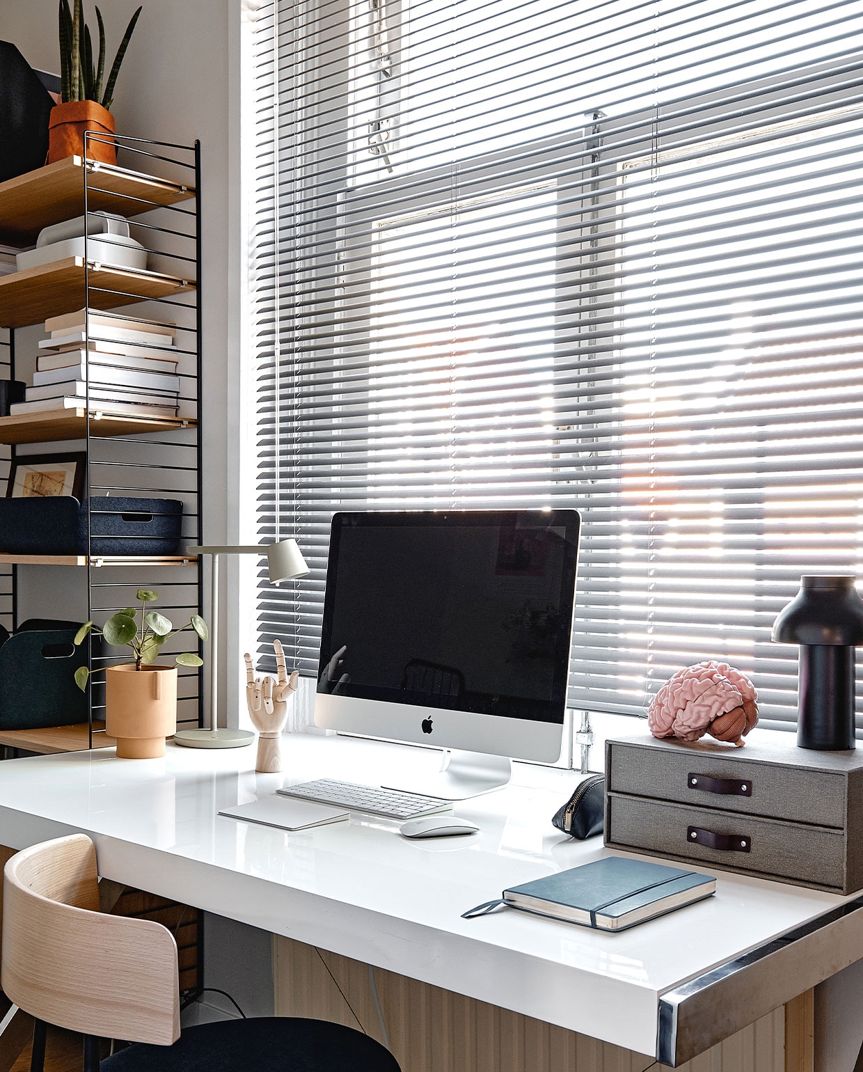 Op de tweede verdieping is ook een werkplek gemaakt. Wandrek Pocket van String Furniture. Stoel Friday van Fest Amsterdam. Bureau Ikea. Plantenpot Oyoy, bureaulamp Muuto, zwarte draadloze lamp Hay.