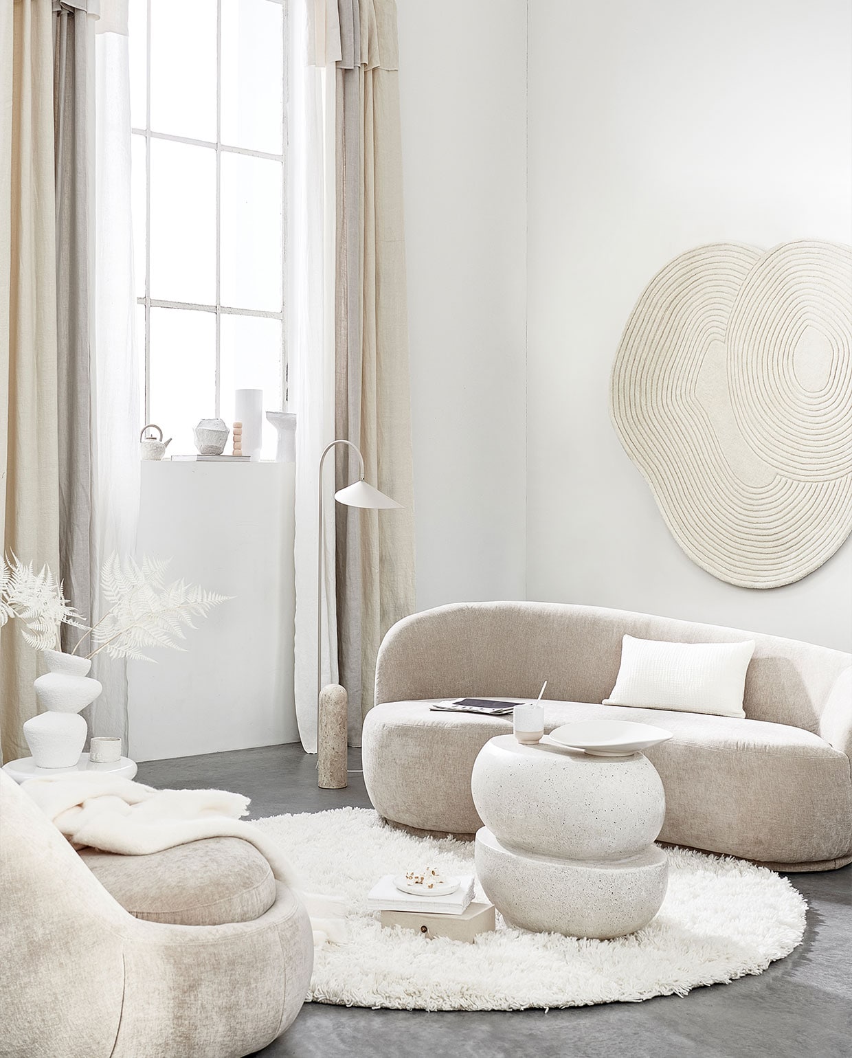 Fauteuil, 176x100x74 cm (bxdxh) € 599,-, bank € 999,- (sofacompany.com). Gordijnen gemaakt van linnen stof Brera Lino in kleur Calico, Putty en Oyster van Designers Guild, per meter € 86,- (wva). Vloerkleed van Linie Design € 700,-, witte bijzettafel van Pols Potten € 294,99, vloerlamp van Ferm Living € 679,- (vtwonen.be). Wollen plaid € 119,-, keramieken theepot € 25,99, wit kussen € 39,99 (zarahome). Keramieken vaas € 29,99 (hm.com). Witte keramieken mok € 22,90 (letoile.store). Geometrische vaas en schaal op voet prijs op aanvraag (julyadrichem.com). Handgemaakte bolletjeskaars, set van drie € 45,- (sukha). Porseleinen vaas € 87,-, vloerkleed aan wand € 630,-, witte keramieken mok met ongeglazuurde onderkant, set van twee € 27,- (bolia.com). Betonnen bijzettafel € 450,- (lanena-home.com). Witte keramieken schaal € 44,95 (urbannatureculture.com). Overig privébezit.
