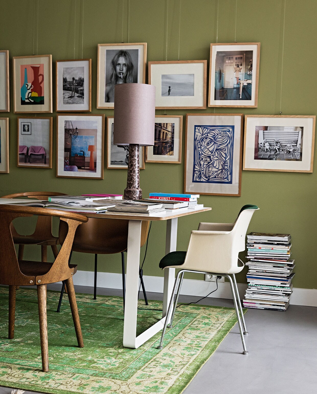 Tafel 70/70 Muuto. Stoelen mix van Fiber Tube Oker en Fiber Wood Dusty Green van Muuto, In Between SK1 Gerookt van &amp;Tradition en vintage Cordemyer van Gispen (groene bekleding) via Best Wel Hip. Schemerlamp en kleed HKliving. Wandverf Boxington van Little Greene. Vloer beton. Kunst eigen verzameling.