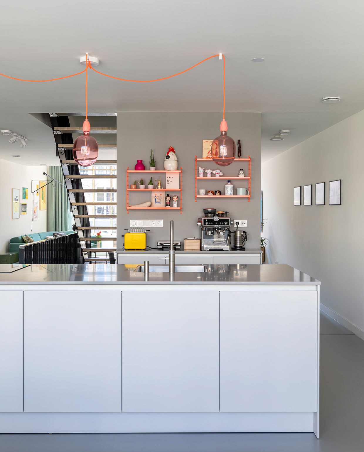 Kookeiland en keukenkasten (achterwand) Pure van Siematic in sterlinggrijs. Lampen Avesta van Calex, fittingen en snoeren van Snoerboer. Neon oranje wandrekken Pocket van String. Espressoapparaat DeLonghi. Kraan Quooker. Verf op de wand Lead van Little Greene. Voorraadpot Cockatoo van &amp;klevering, Kokeshi dolls Elton John en Amy Winehouse van Lucie Kaas, zoutvaatje Friends van Normann Copenhagen, broodrooster kMix van Kenwood, walvis gekocht op Elba, lang houten figuur uit Namibië, sneeuwpopjes knutsels van dochter Sien.