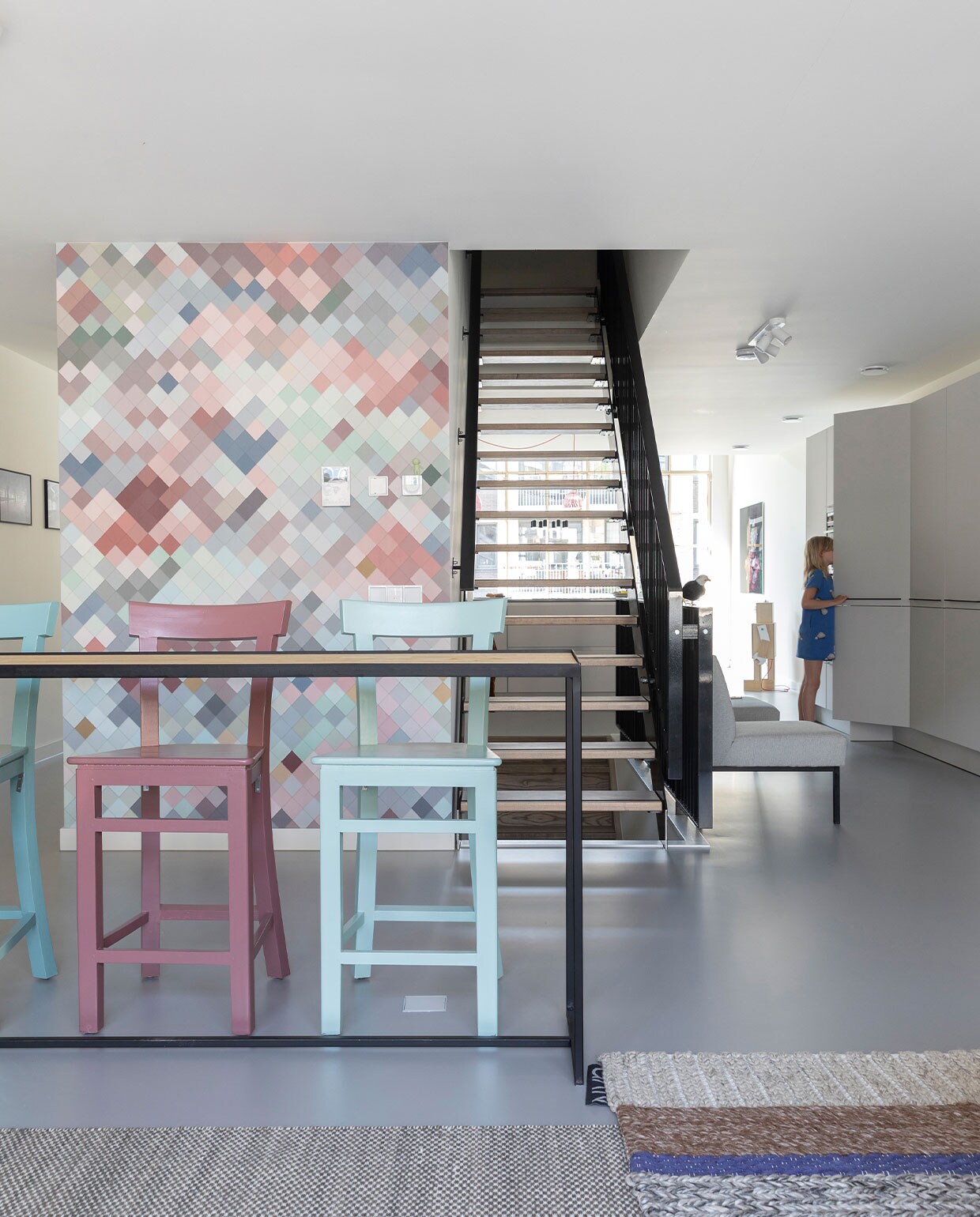 Hoge bartafel zelfgemaakt van een gelast onderstel en een eikenhouten blad. Behang Tiles van Lemon. Groot tapijt Moiré Kelim van Hay, gebreid tapijt Mangas MR2 van Gan Rugs. Barkrukken Marktplaats. Overig onbekend.