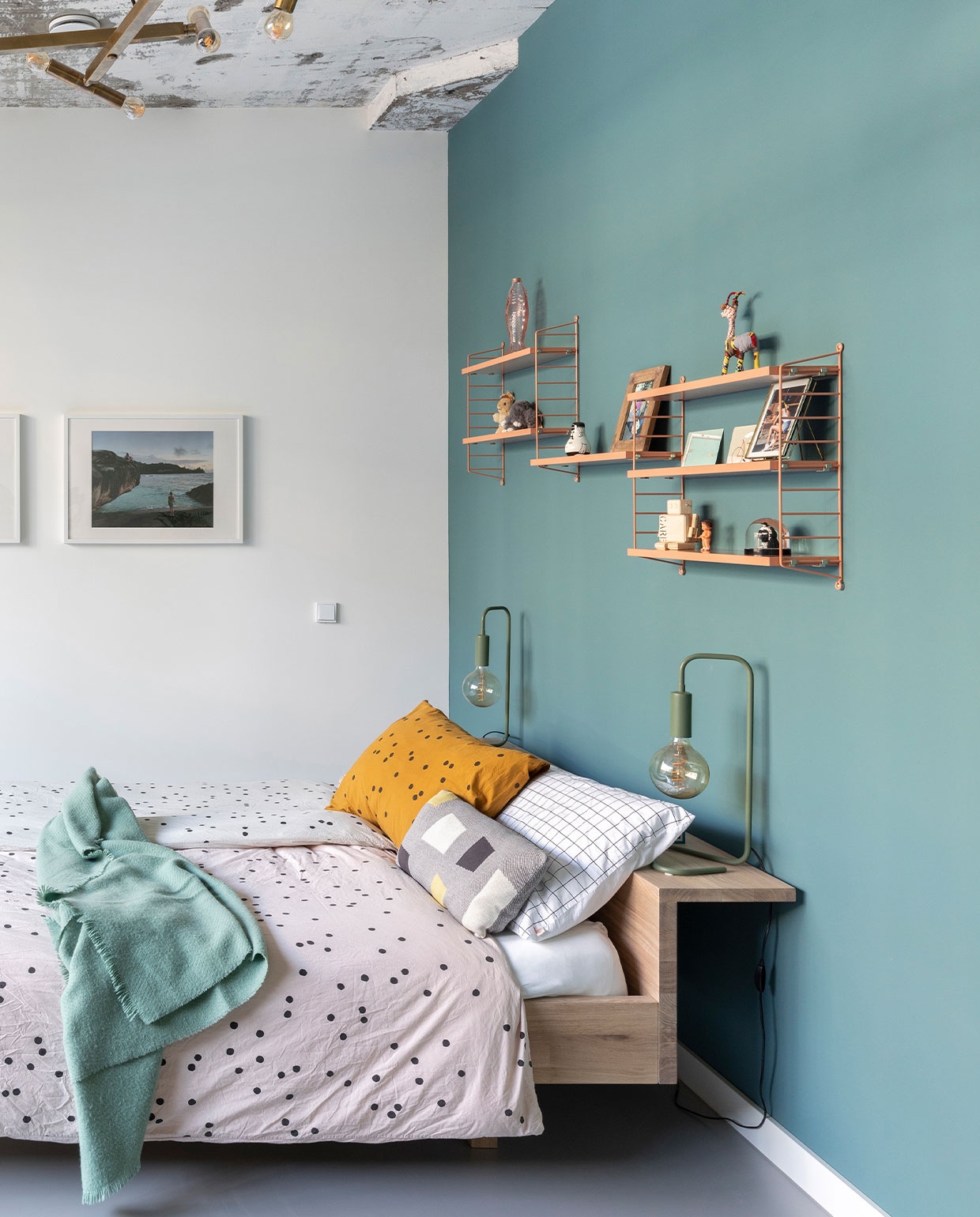 Eikenhouten bed Nachtleven. Blush pink wandrekken Pocket van String. Bedlampen Sissy-Boy. Beddengoed La Cerise sur le Gâteau. Verf op wand Tea with Florence van Little Greene. Vintage kroonluchter. In de wandrekken houten robot Mini-Rijkswachter van Hamerhaai. Poppetje oud speelgoed van Dieke’s moeder. Sneeuwbol/glitterbol Maarten &amp; Oopjen (van Rembrandt) van &amp;Klevering. Stoffen okapi gekocht in Namibië. Pepervaatje deel van Friends van Normann Copenhagen. Konijnen oude knuffels van Dieke. Foto’s vakantiefoto’s van de Seychellen