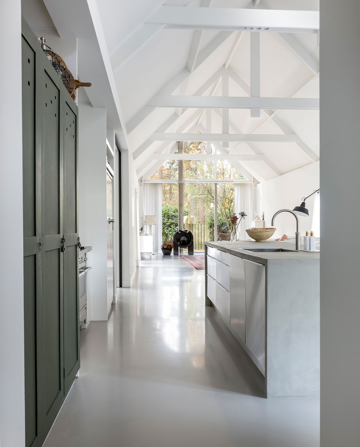 Keuken Ikea, keukenblad krasvaste gietvloer van lavasteen, kleur beton, Poolse legerkast vintage, krijtverf legerkast in kleur Verruiming van Histor, fruitschaal Loods 5, kraan Quooker, koelkast en fornuis Boretti, zeep en handcrème Rituals, mand met hout Kwantum.