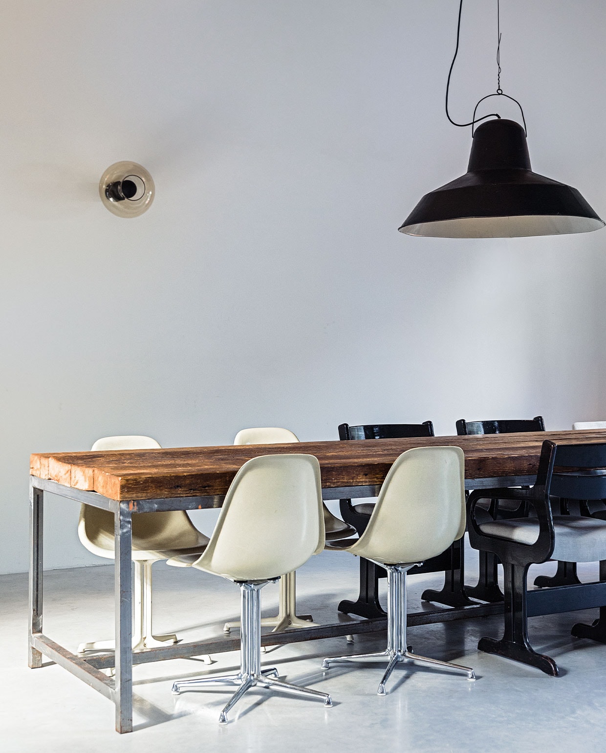 Eettafel, stoelen en lampen vintage. Vloer van gevlinderd beton via Bako Beton.