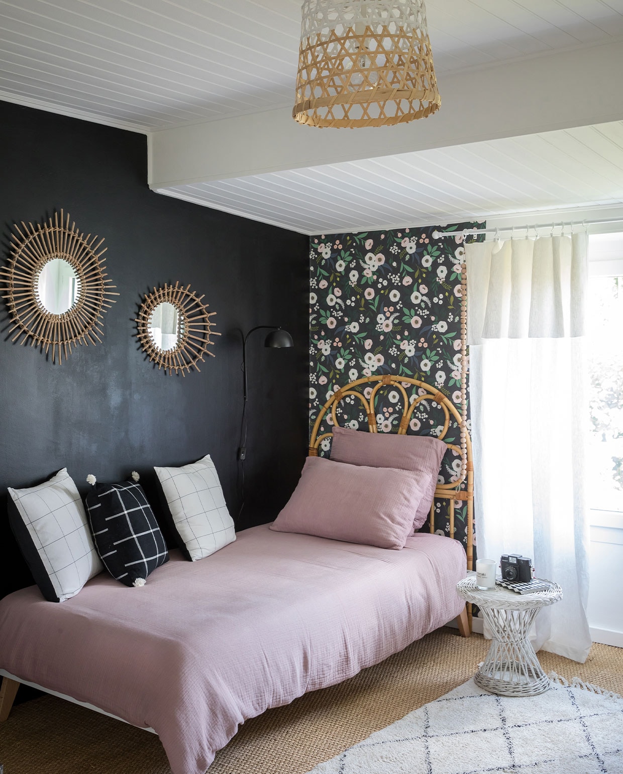 Behang Lilipinso, vloerkleed Søstrene Grene, bed File dans ta Chambre, rotan hoofdeinde Selency, bedlinnen AM.PM via La Redoute, zwart geruit kussen Kasbah Chic, witte kussens Bouchara. Zeegrasvloer Saint-Maclou, rotan bijzettafel uit Virginies jeugd, lamp Søstrene Grene, rotan spiegel Le Bon Coin. Overig onbekend.