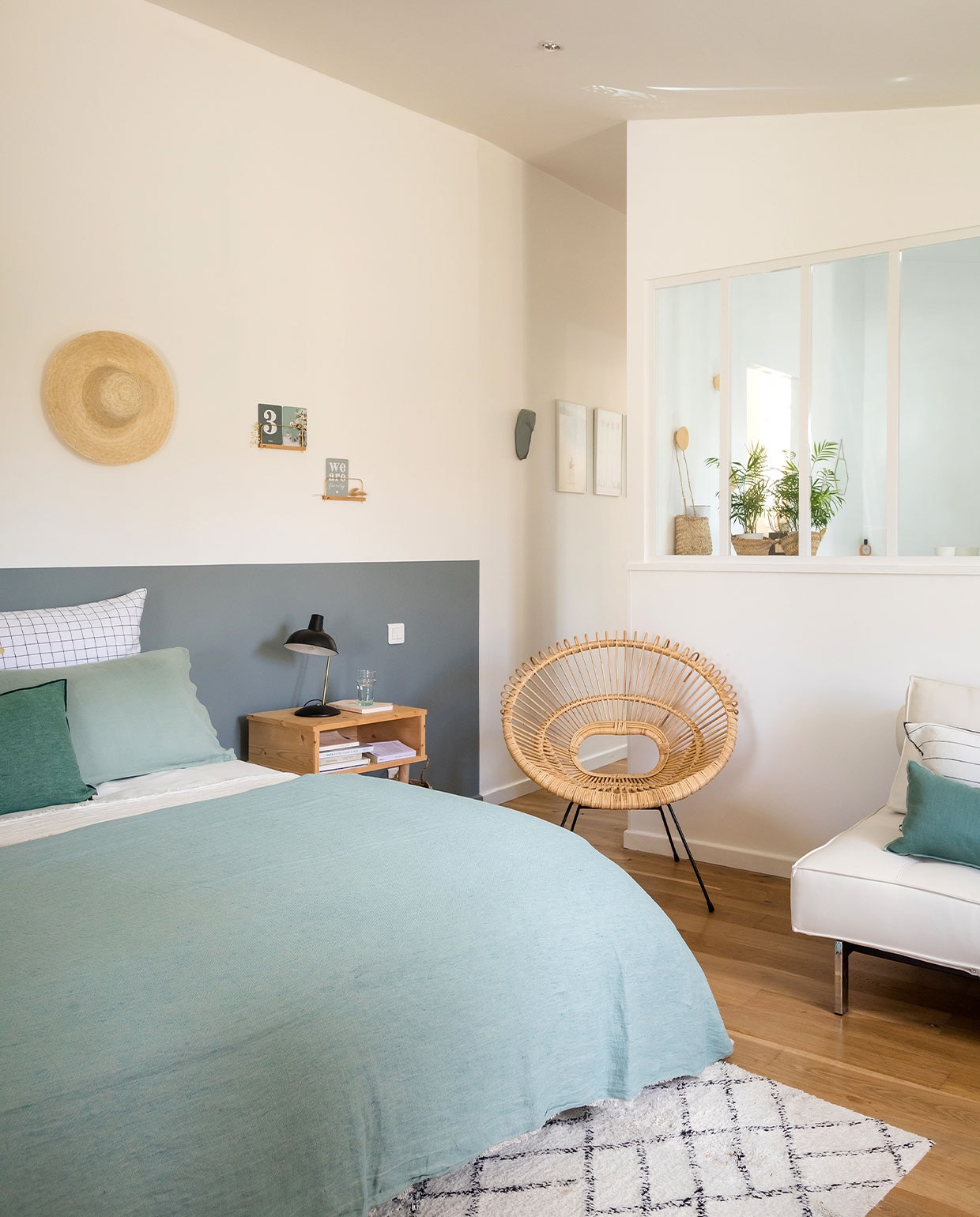 Grijze muurverf Breutter Grew van Benjamin Moore, bedlinnen Harmony Textile, plaid en groene kussens Maison de Vacances, tapijt Søstrene Grene, stoel 4murs. Overig onbekend.