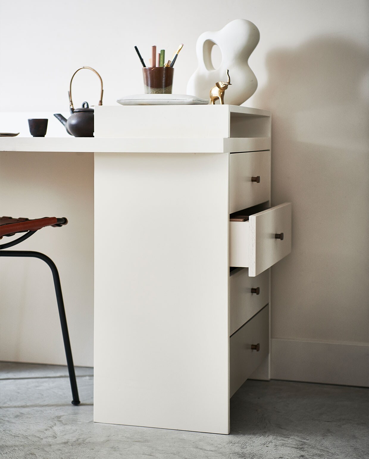 Verf op muur Mushroom nr. 142 (littlegreene). Theepot met kopje € 35,99, bruin/groene mok € 15,99, groen/bruine aardewerken pot met kaars € 19,99, rond klein bordje, per stuk € 11,99, sisal vloerkleed, 160×230 cm € 279,- (zarahome.com). Organische decoratieve steen € 24,99 (hm.com). Gouden tafellamp Reflection van Bolia € 364,99 (vtwonen.be). Overig privébezit.
