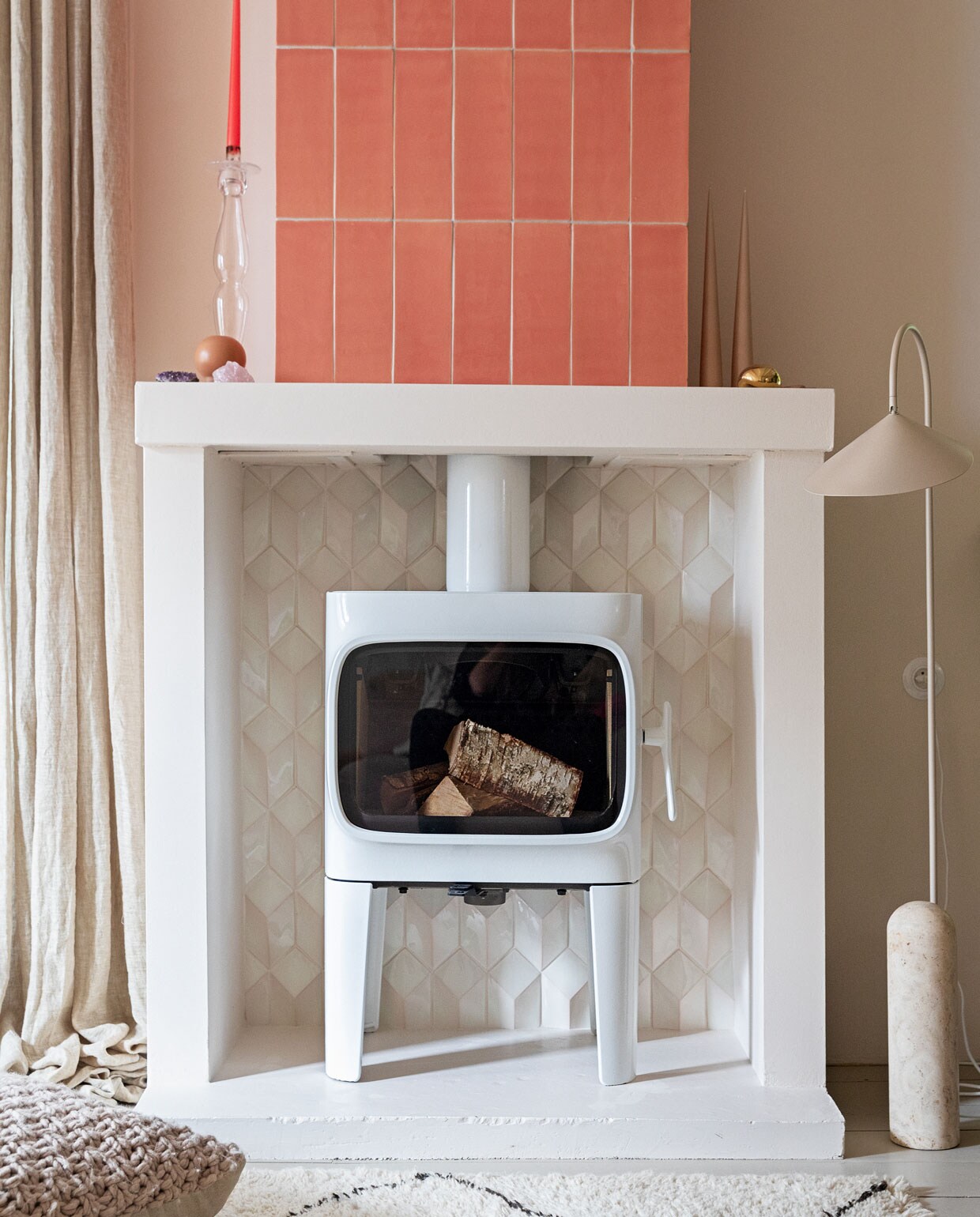 Houtkachel Jøtul F305. Tegels 10×30 cm kleur Flamingo Baby en witte tegels Constellation kleur Eggshell White via Quintalisque. Kussen Sukha. Lamp en kiezel Ferm Living. Glazen kandelaar herkomst onbekend. Kaarsen Ester &amp; Erik.