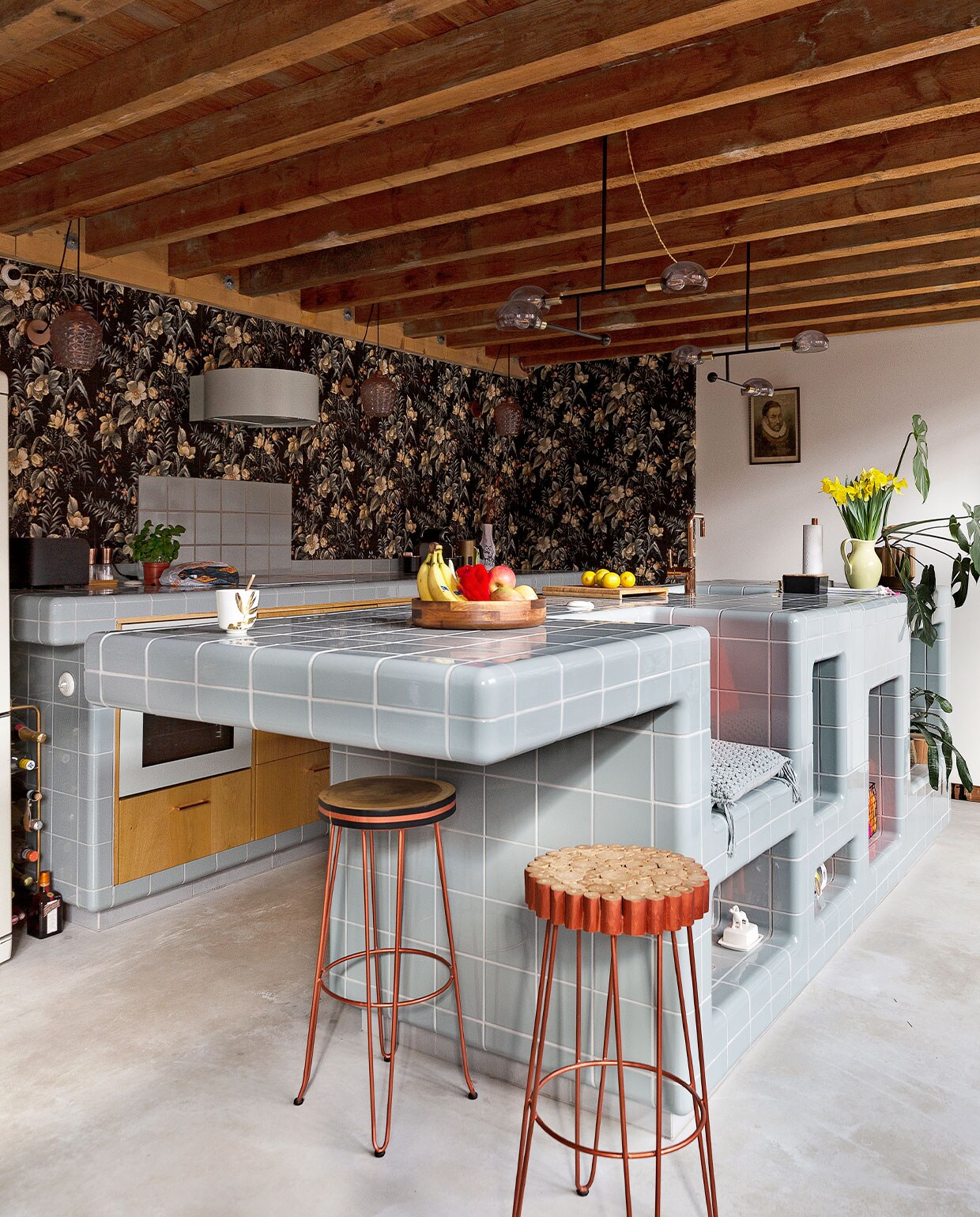 Keuken van D-tile in de kleur Duif. Kookplaat, afzuigkap en oven Ikea, kraan van Nivito, ­afneembaar behang Hornbach, lampen Tangle via made.com, barkrukken Kave Home.