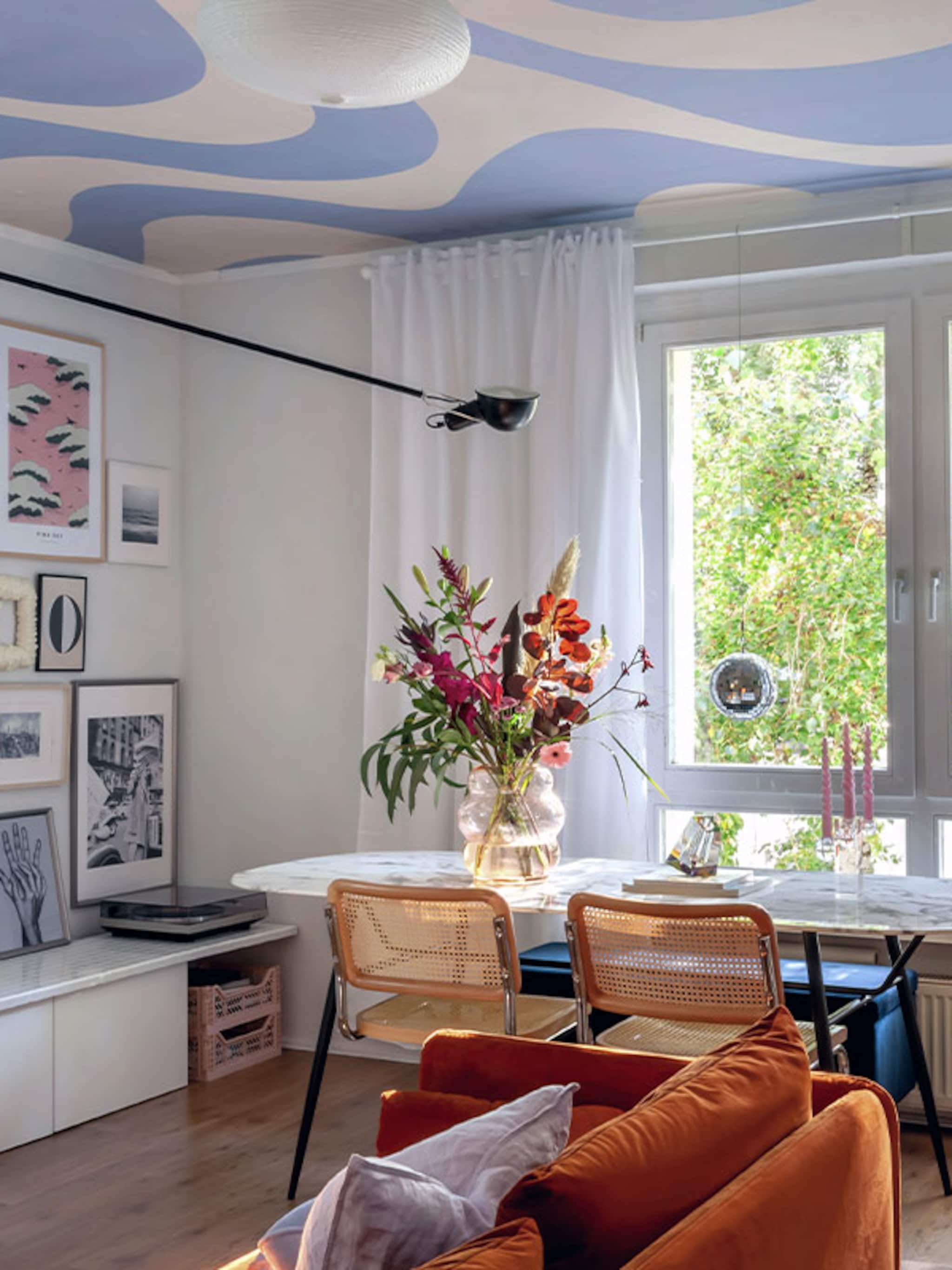 binnenkijken in een kleurrijk en klein huurappartement met behang op het plafond
