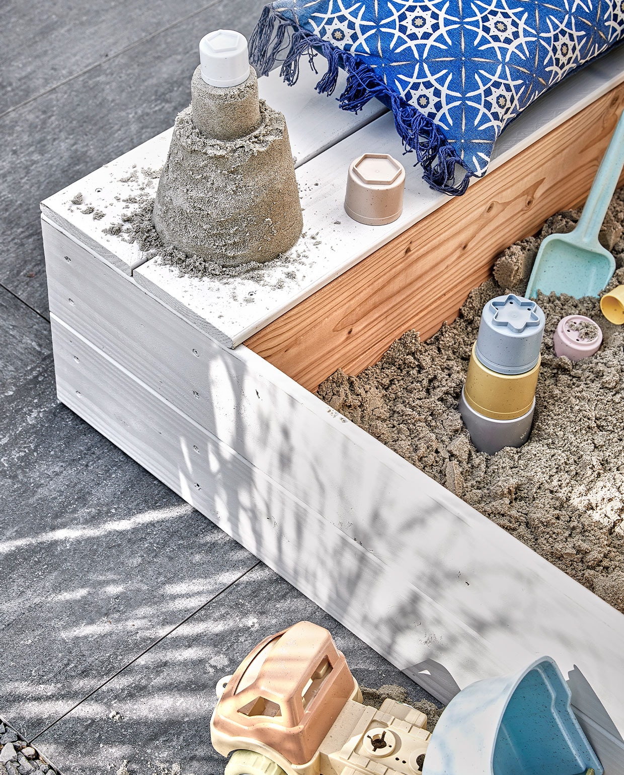 Kussen Grace € 29,99 (intratuin). Zandset € 19,95 en klepwagen € 22,95 van Bio-toys (ilovespeelgoed.nl). Schepje € 2,50 (hema). Laarsjes € 9,99, kinderbezem € 6,49 (intratuin). Zonnehoedje € 9,99 (zara.com). Overig privébezit.