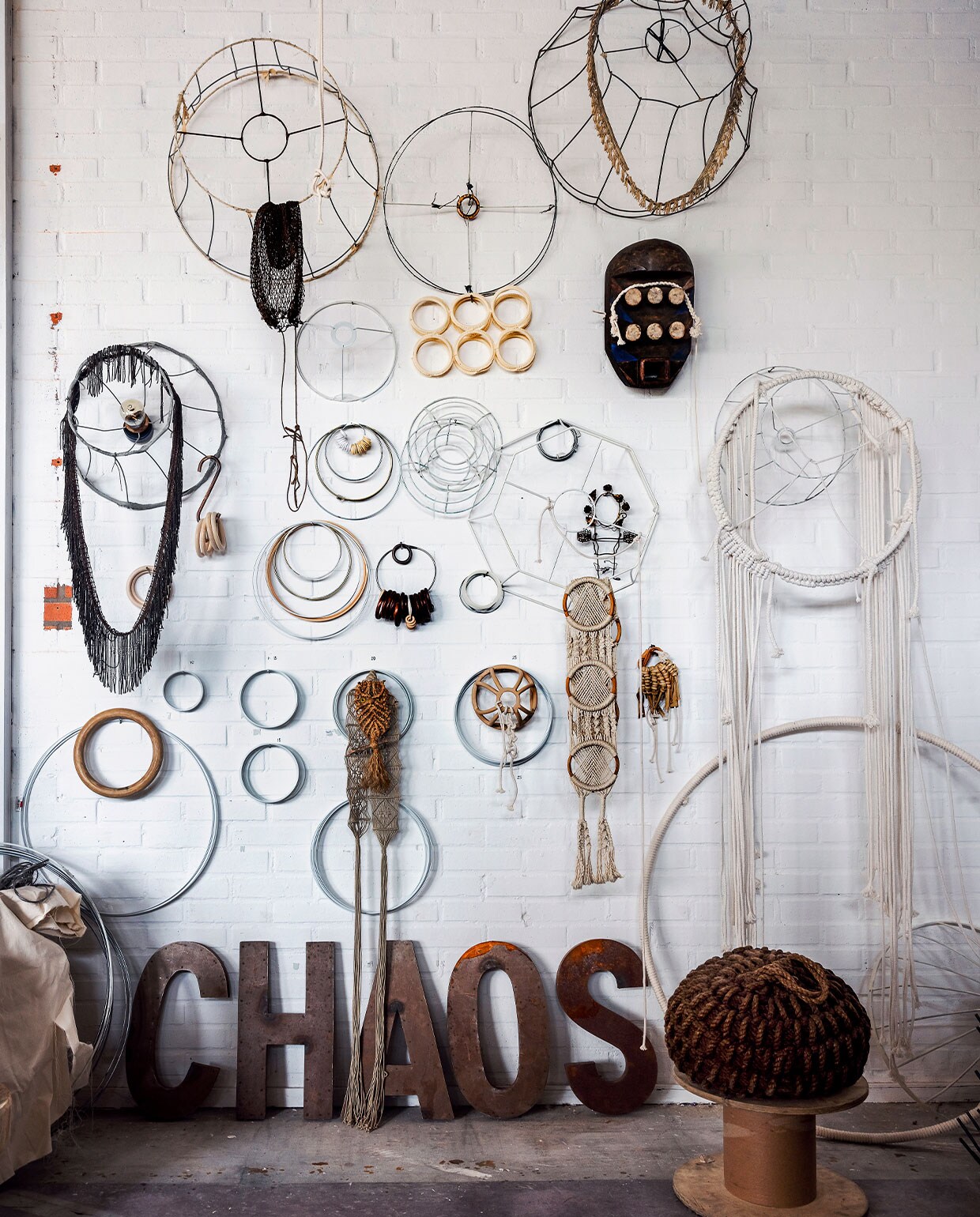 ‘Deze wand hangt vol verzamelingen die mij inspireren, van geknoopte uilen tot vintage textiele werken en oude lampenframes. Die frames lijken op de ringen die ik verwerk in mijn sculpturen.’