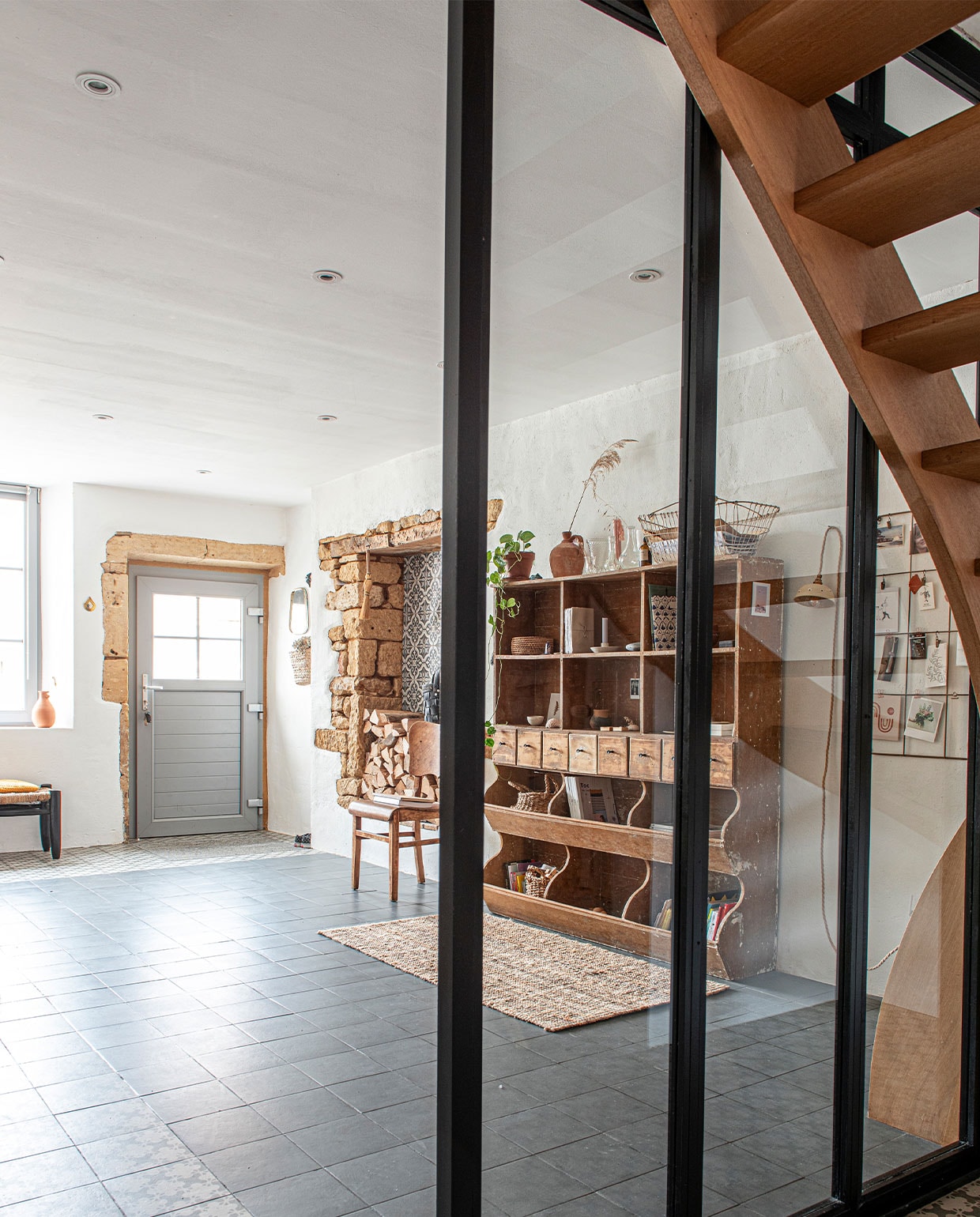 Antieke kruidenierskast, daarop vintage potten, glaswerk en mand, vintage stoel, karpet Ikea, vloertegels collectie Azulej van Mutina, kruk onder raam Couleur Locale (Knokke), vaas in raam van lokale bloemist, kaarthouder Madam Stoltz, muurlamp zelfgemaakt.
