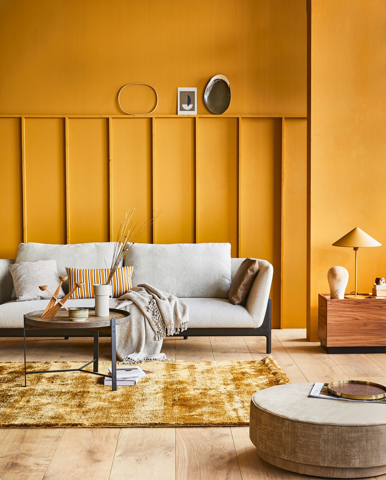 Muurverf DesertM.m.v. design020.nl (bank van Bensen), goeds.nl (salontafel), restored.nl (grijze porseleinen kan), &amp;klevering.nl (kandelaar), vtwonen.nl (gele tafellamp Triangle van HKliving, vloerkleed Nami van Bolia, gestreept kussen van Normann Copenhagen, plaid van Kaat Amsterdam, bijzettafel Block en ronde poef Pearl uit de vtwonen collectie), vandijkenko.nl (hoofd), casagitane.com (bord), hm.com (dienblad). vtwonen 04-2020 | productie Tanja Saarberg | styling Cleo Scheulderman | fotografie Jeroen van der Spek