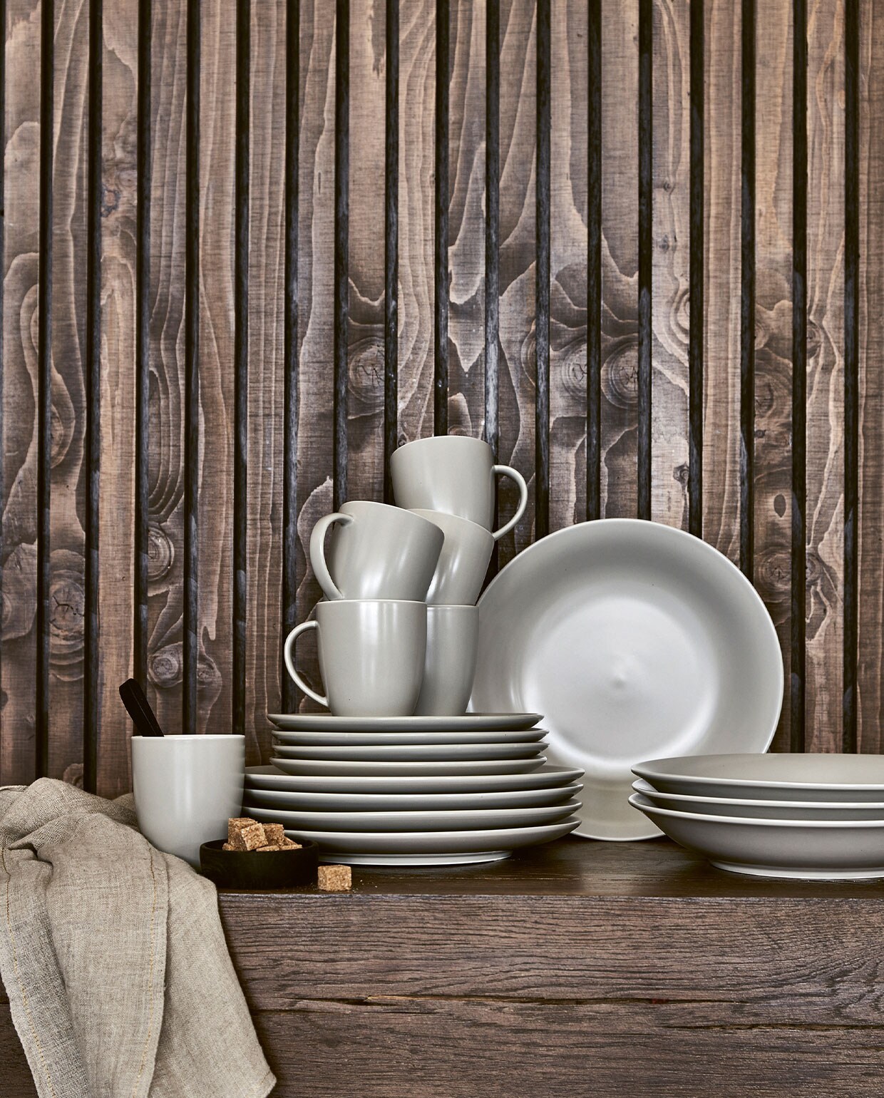 Zandkleurig mat (flax wit) porseleinen servies 16-delig € 99,-, 36-delig € 239,-. Zandkleurige theedoek met visgraatmotief, 50×70 cm € 9,95, ook verkrijgbaar in blauw en grijs. Matzwarte theelepels, set van 6 € 25,-.