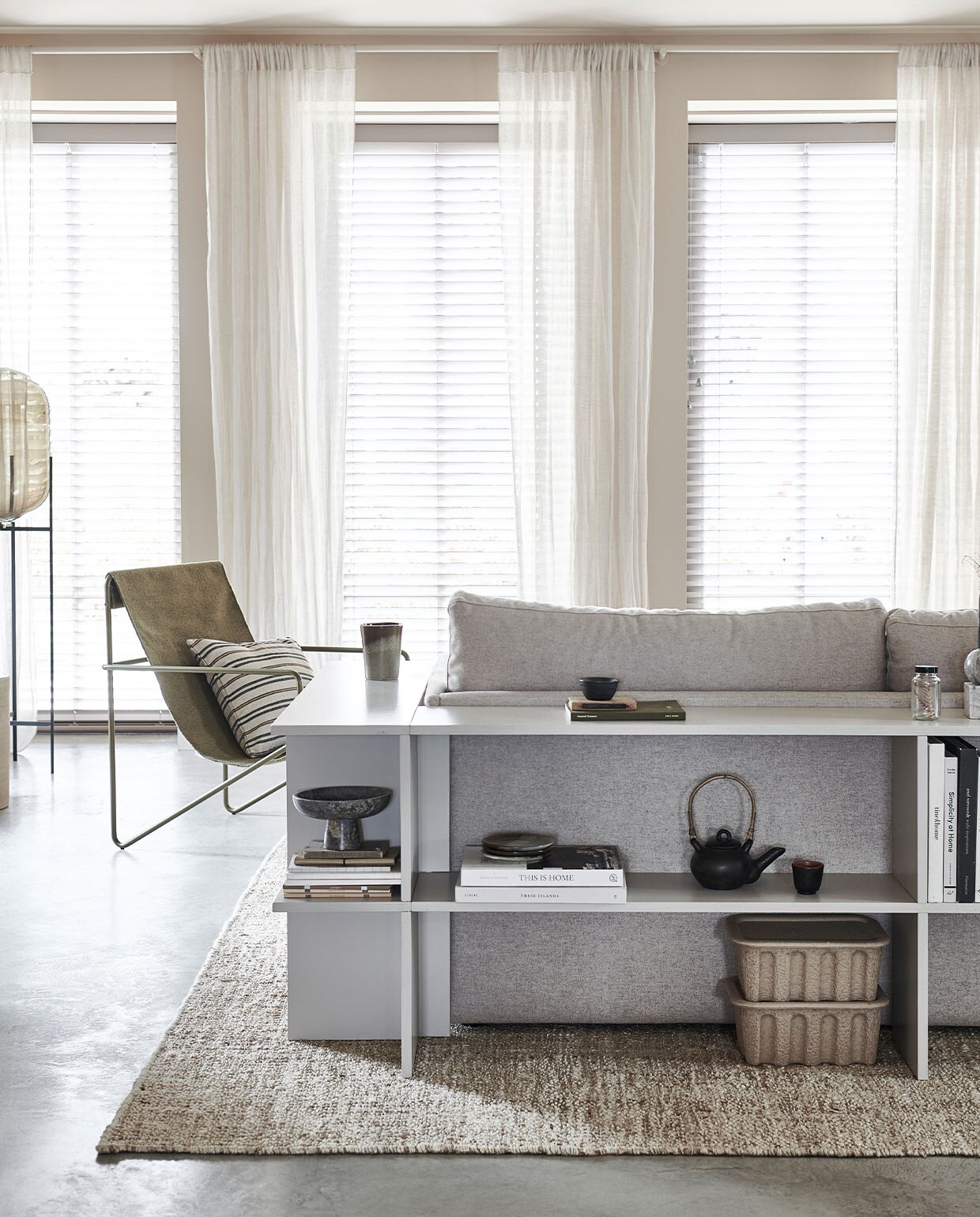 Verf op de muur Mushroom 142 (littlegreene). Ruime driezitsbank Cube in stof facet kiezel € 3610,- (studio-henk). Papierpulp dozen per 2 stuks vanaf € 35,- (misterdesign). Juten vloerkleed, 300×400 cm € 599,-, theepot met kopje € 35,99, gestreept kussen, 45×45 cm € 17,99, bordjes per stuk € 11,99, mok € 15,99, linnen plaid, 230×250 cm € 149,- (zarahome.com). Bouclé poef Clover van Pols Potten € 270,-, fauteuil Desert van Ferm Living € 249,30, metalen plantentafel van Ferm Living € 289,-, goudkleurige vloerlamp Reflection van Bolia € 509,99 (vtwonen.be). Vaas vlekken € 34,99, marmeren schaal op voet 29,99 (hm.com). Zwarte houten schaal van Urban Nature Culture € 52,95, mini-vaasje Vulca grey dots van Ferm Living € 15,- (nijhofbaarn). Overig privébezit.