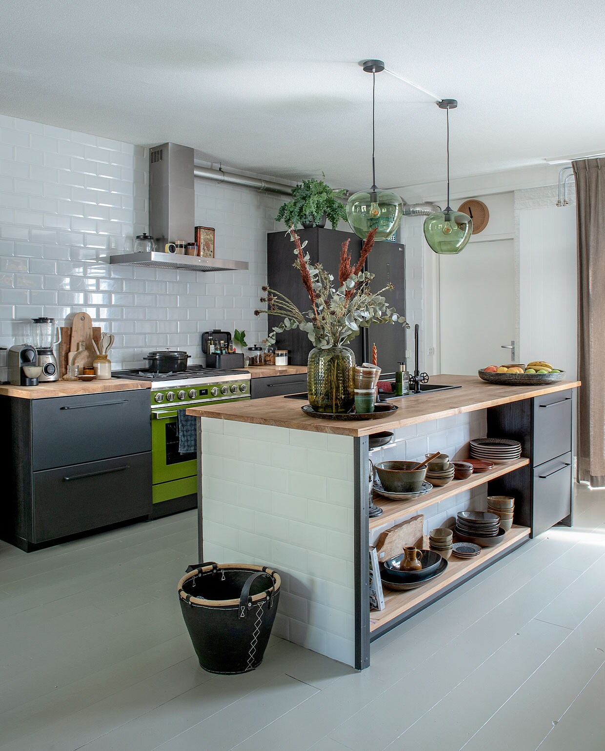 Keukenkasten Kungsbacka, wasbak en kraan van Ikea. Teakhouten werkbladen op maat gemaakt. Fornuis Smeg. Metrotegels Praxis. Hanglampen Light &amp; Living. Pan Albert Heijn, blender Philips, koffieapparaat Krupps. Koffer Kwantum, vaas Intratuin, klok Zuiver. Theedoek Hema. Servies Xenos, Mica Decorations, Kitchen Trend, Kwantum. Mand van oude fietsbanden Leen Bakker. Verf vloerdelen Rijksmuseum groen van Sikkens.