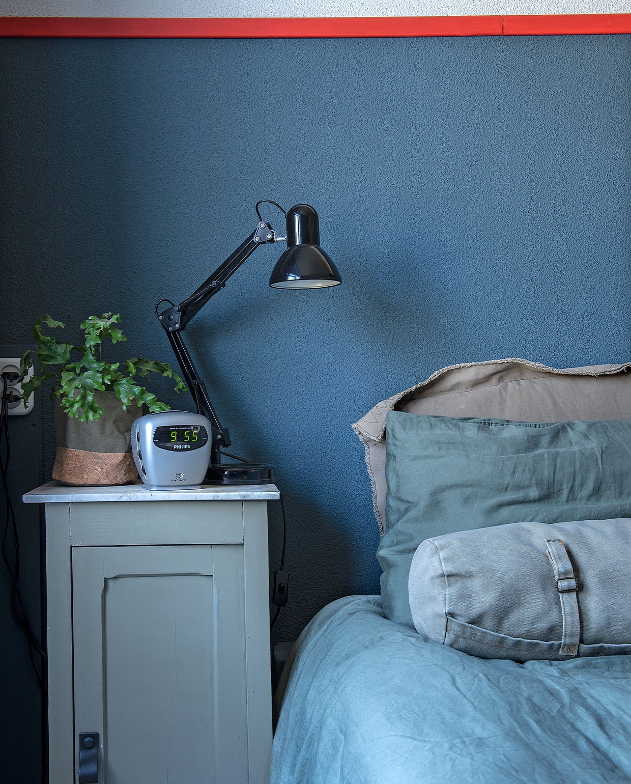Verf wand- en kast Vintage blauw van Karwei. Nachtkastje kringloop. Wekker Philips, bureaulamp Kwantum, bloempotzak Intratuin, bedlinnen , rolkussen Loods 5, grijs kussen onbekend.