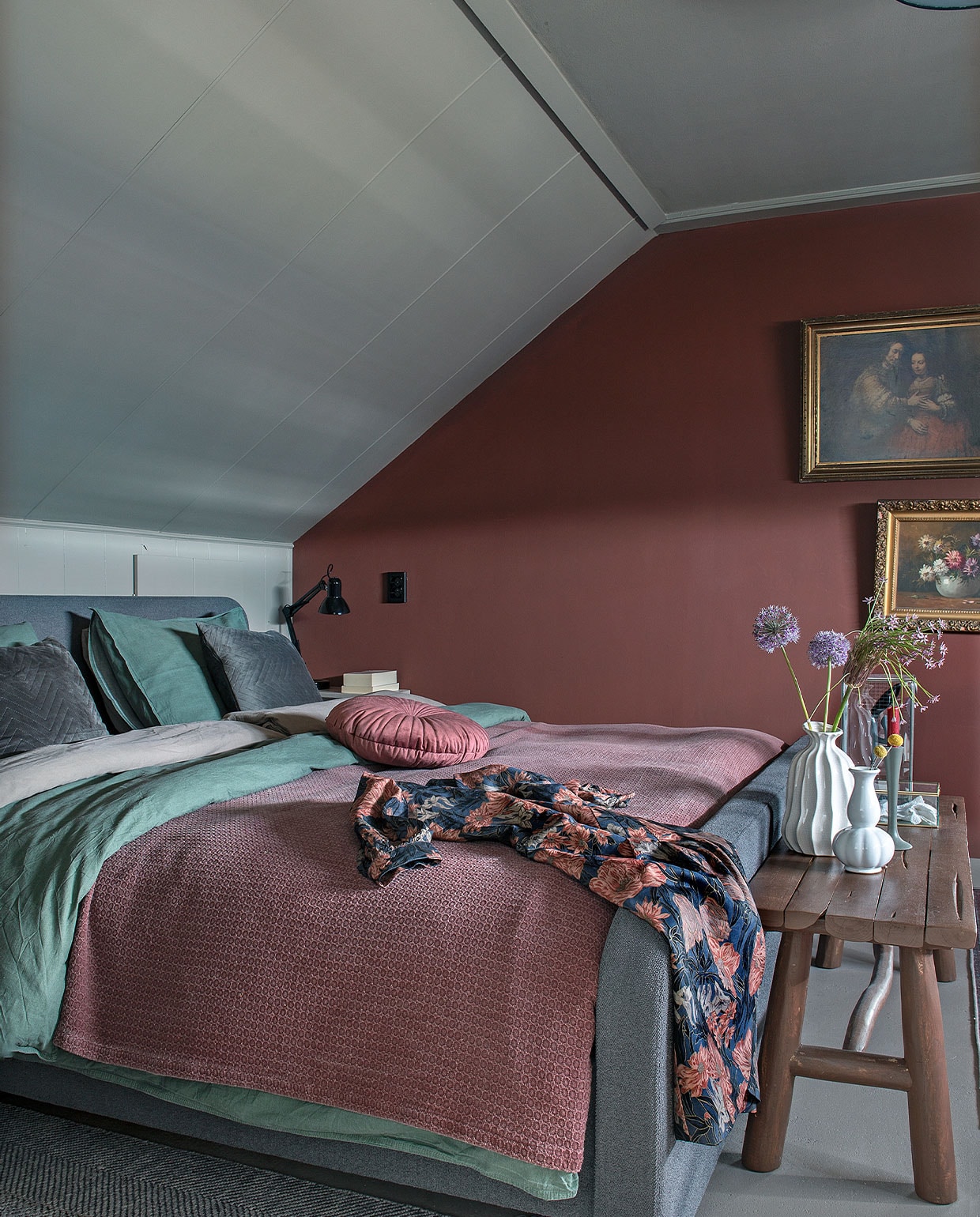 Wandverf bordeauxrood IG PS 1061 en licht IG PS 1045 van Karwei. Bed van Eastborn. Groen bedlinnen Walra, rood plaid Jysk. Bank Xenos geverfd in dezelfde kleur als de kast. Bloemenschilderij is een erfstuk. Overig kringloop.