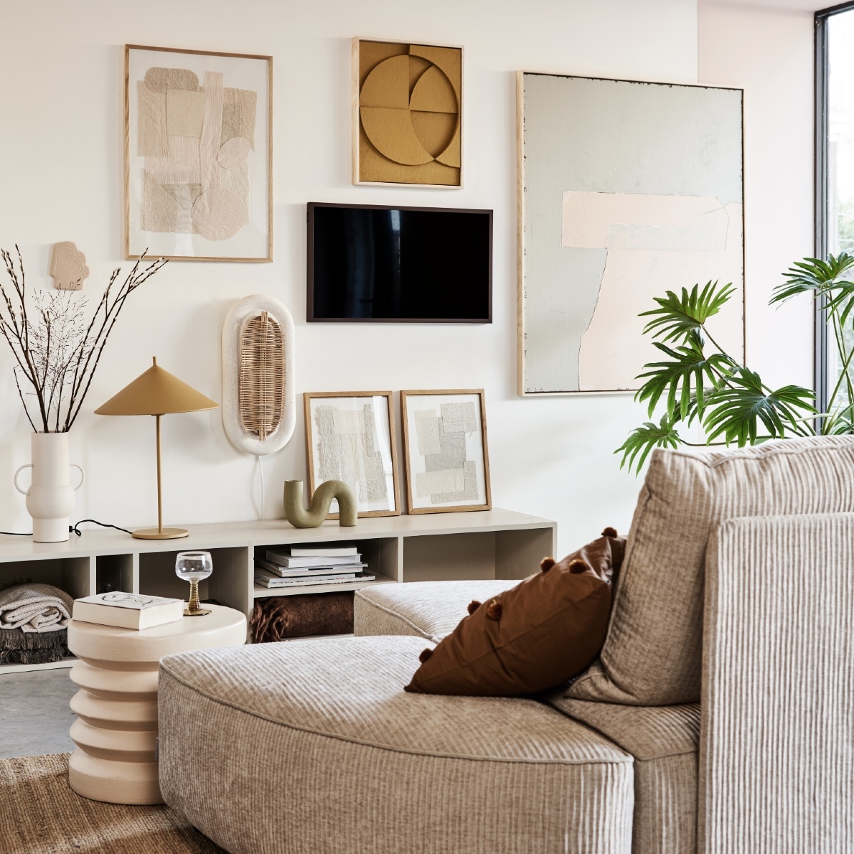 Televisie The Frame 32 inch € 429,-, verwisselbare walnoothouten lijst The Frame € 129,- (samsung). Kast in kleur Skimming Stone 241 van Farrow &amp; Ball AFMETING € XXX,- (combitex). Handgemaakte ovalen wandlamp NAAM € 299,- (lanena-home.com). Sofa Hunter bestaat uit diverse losse onderdelen: poef € 419,-, element met rug € 1009,-, element zonder rug € 419,- (zuiver). Bruin sierkussen met pompons van MERK € 29,95, roze bijzettafel van MERK € 159,-, vaas van MERK AFMETING € 47,95 (vtwonen.be). Hennep vloerkleed 180×280 (bxl) € 395,-, olijf/nude-kleurig abstract kunstwerk (rechts) 100×120 cm (bxh) € 549,-, okergeel kunstwerk boven tv van 43x4x53cm (bxdxh) € 329,-, taupekleurig wandornament Face € 37,95, crèmekleurige bijzettafel 38×36 cm (Øxh), wijnglazen met groene voet € 9,95, okergele lamp Triangel € 149,- (hkliving). Stoffen kunstwerk in eikenhouten lijst € 89,-, kunstwerken in lijst op kast, per stuk € 69,- (sur-atelier). Bruine en beige katoenen plaids in dressoir 130×170 cm per stuk € 45,99 (zarahome.com). Donkerbruin plaid rechts in dressoir 130×170 cm (bxl) € 65,- (maisonnl.com). Overig privébezit.