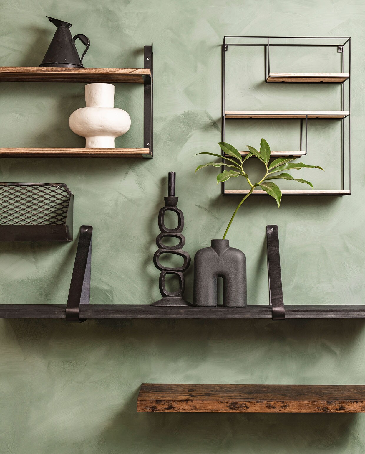 De wand is eerst behandeld met LAB Eco Chalk Primer, per liter € 44,-, daarna geverfd met LAB Eco kalkverf in de kleur Soft Fern, per liter € 54,- (vestingh). Lifegoods wandplankenrek € 35,99, zwart metalen wandrek met houten plankjes van Brute Strength € 29,95, rustieke zwevende wandplank van Acaza € 31,98 (bol.com). Zwarte oliekan € 43,95 (hetkabinet). Witte vaas € 68,95, kandelaar € 27,95, zwarte vaas € 55,95 (loftloft). Zwart leren plankendragers € 19,95, exclusief zwarte plank (karwei.nl). Metalen gaasplank € 69,- (brut).