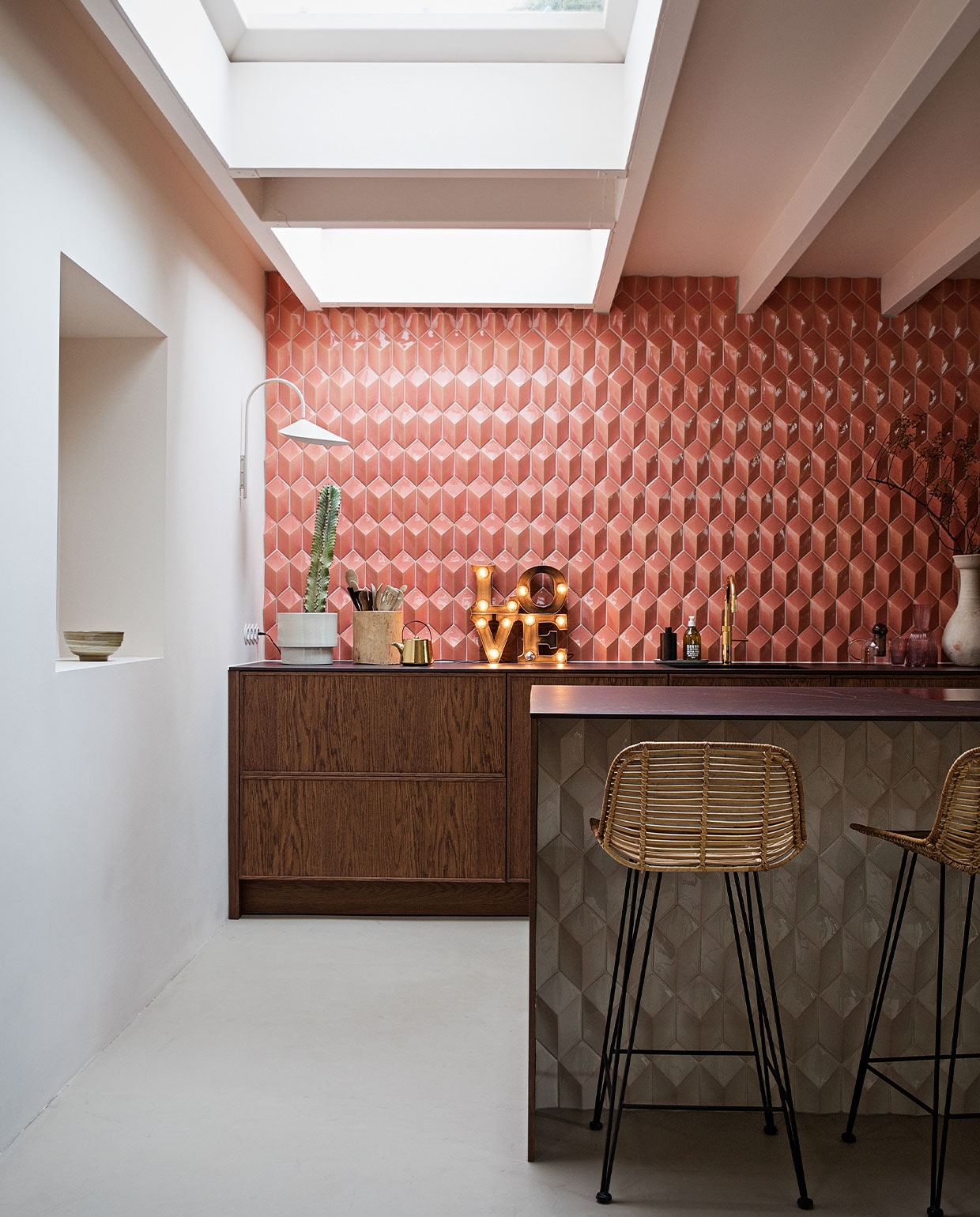 Barkrukken, theepot en kom in nis HKliving. Wandlamp Ferm Living. Love lamp Sissy-Boy Homeland. Tegels Constellation kleur Flamingo Baby via Quintalisque. Kraan Quooker. Houten pot Household Hardware. Bloempot  Planten Blóm. Overig herkomst onbekend.