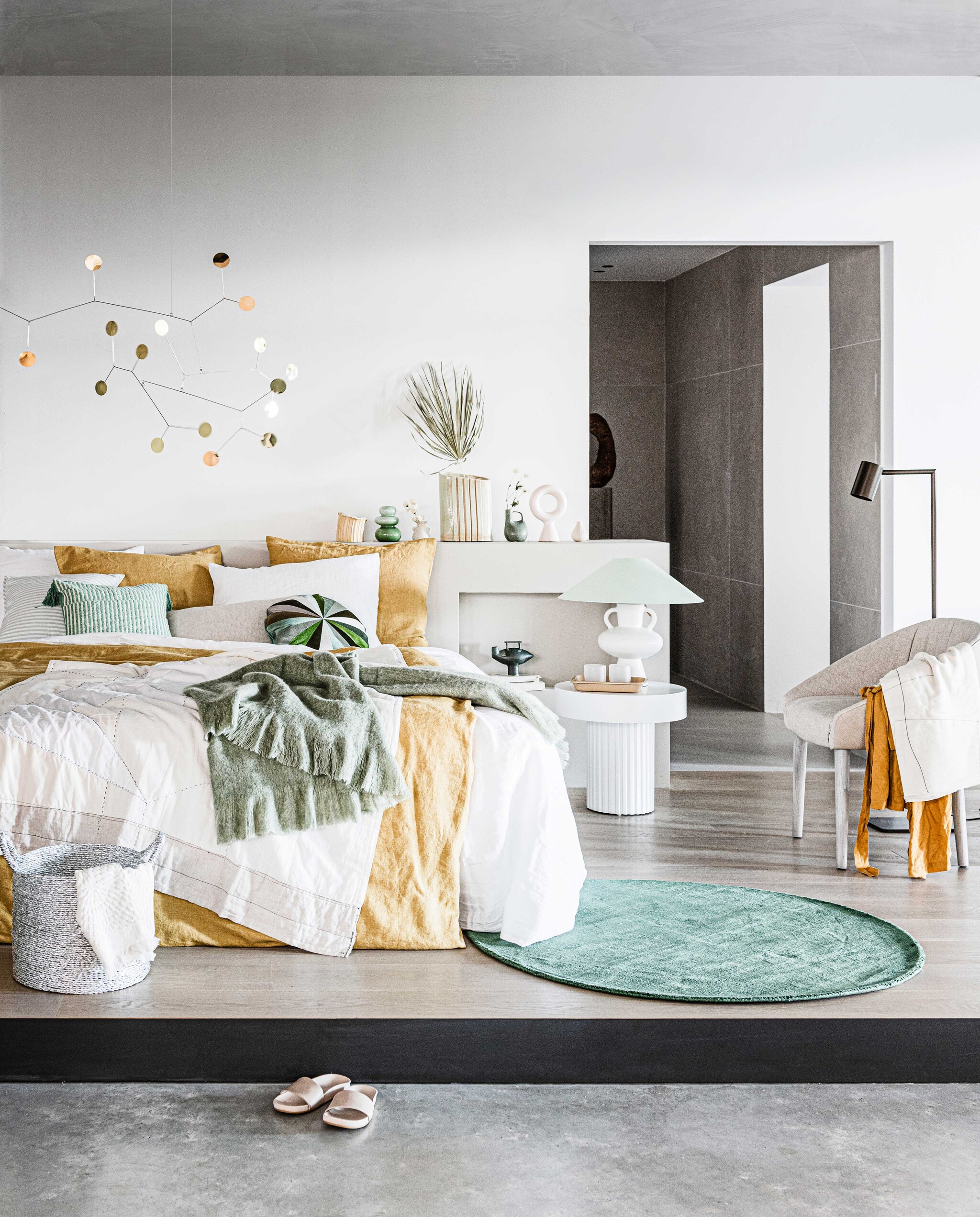Mobile € 380,- (lpln.de). Geel linnen dekbedovertrek Honey, 140×220 cm € 249,-, wit linnen dekbedovertrek Pure White 140×220 cm € 249,-, linnen kussensloop Honey en Pure White vanaf € 28,- (bymolle.com). Gele vaas boven bed van Floris Wubben, maat M € 180,-, groene vaas met tak erin van Floris Wubben € 395,- (frozenfountain.nl). Groene glazen € 29,95, groen vloerkleed Ø 170 cm € 145,-, mand € 27,95, witte kleine vaas € 16,95 (loods5.nl). Tafel Pillar van HKliving € 249,-, wit ronde ornament Chulucanas van HKliving € 42,95, groene plaid van HKliving 150×125 cm € 64,95 (vtwonen.nl). Witte stenen lampenvoet maat L van HKliving € 119,-, groene lampenkap van HKliving € 79,95 (woononline.nl). Vloerlamp Tribe brons van Piet Boon by Maretti € 448,99, stoffen stoel Cara rechts € 1489,-, twee glazen op nachtkast van Piet Boon by Serax, per stuk € 11,50 (pietboon.com). Wit gestikt plaid op bed € 399,-, leren slippers € 189,-, wit gestikte sjaal over stoel € 179,- (sukha.nl). Lichtgroen met wit gestreept kussen € 22,99, groen met wit gestreept kussen met kwast € 22,99 (zarahome.com). Wit gastendoekje in mand € 5,99, gele linnen badjas € 39,99 (hm.com). Bruin dienblad op nachtkastje, prijs op aanvraag (hayonlinewinkel.com). Overig privébezit.