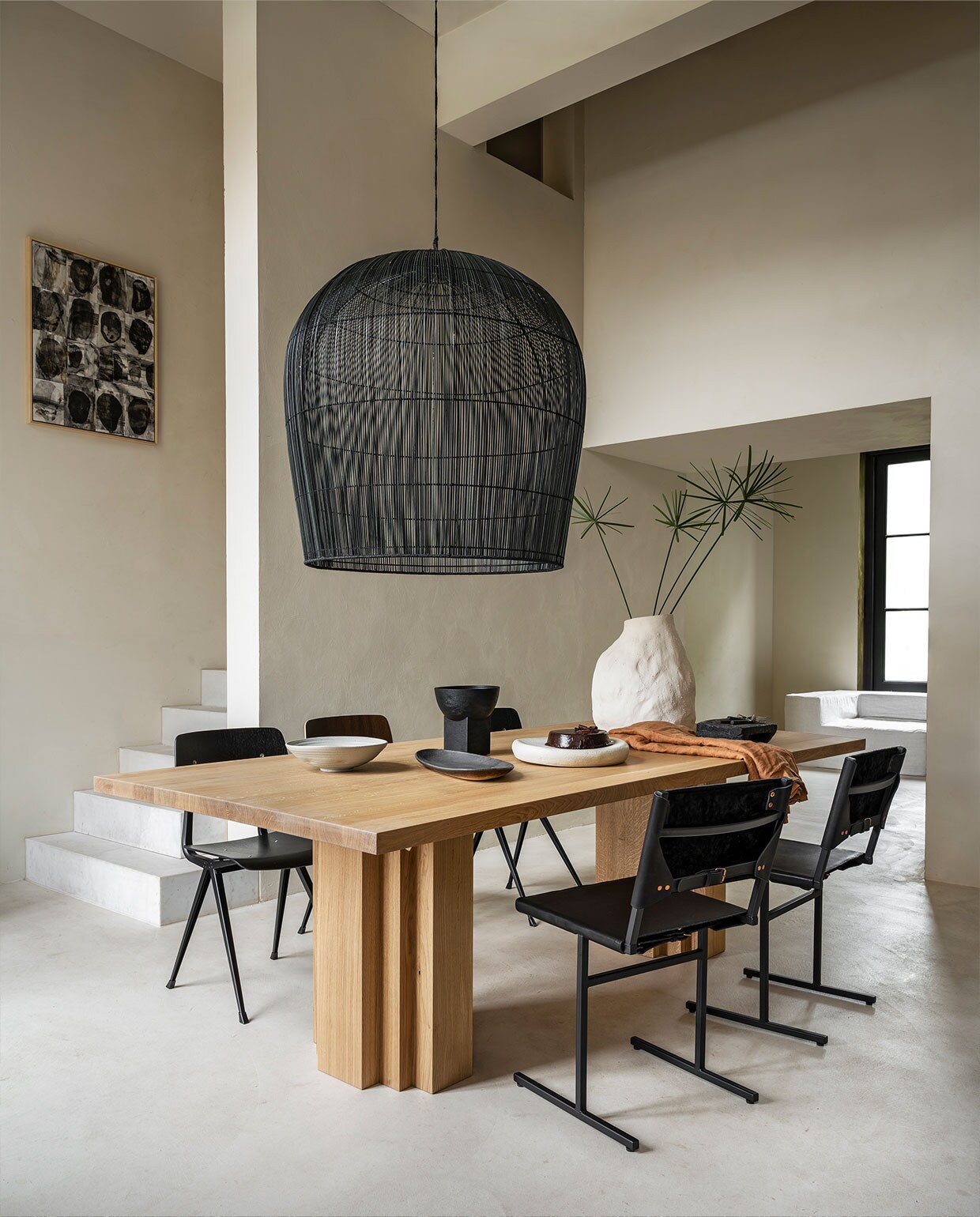 Eikenhouten tafel Brut van Aad Bos, 240x110x75 cm (lxbxh) € 4300,- (mokkoamsterdam.com). Rieten lamp van Ay IIluminate, 95 cm (h) € 1750,-, stoelen Result van Hay € 269,-, vaas Vulca van Ferm Living € 199,- (vtwonen.be). Stoelen van staal en leer € 490,- (wdstck.eu). Handgemaakte schalen in verschillende vormen vanaf € 75,- (marjokedeheer.com). Houten schaal op voet € 49,95 (urbannatureculture.com). Schilderij van Marlies Hoevers, prijs op aanvraag (hoeversid.com). Bank met linnen hoes, zijkant 120x120x60 cm (lxbxh), tussen-stuk 120x90x60 cm (lxbxh), per element vanaf € 850,- (10dayslifestyle.nl).
