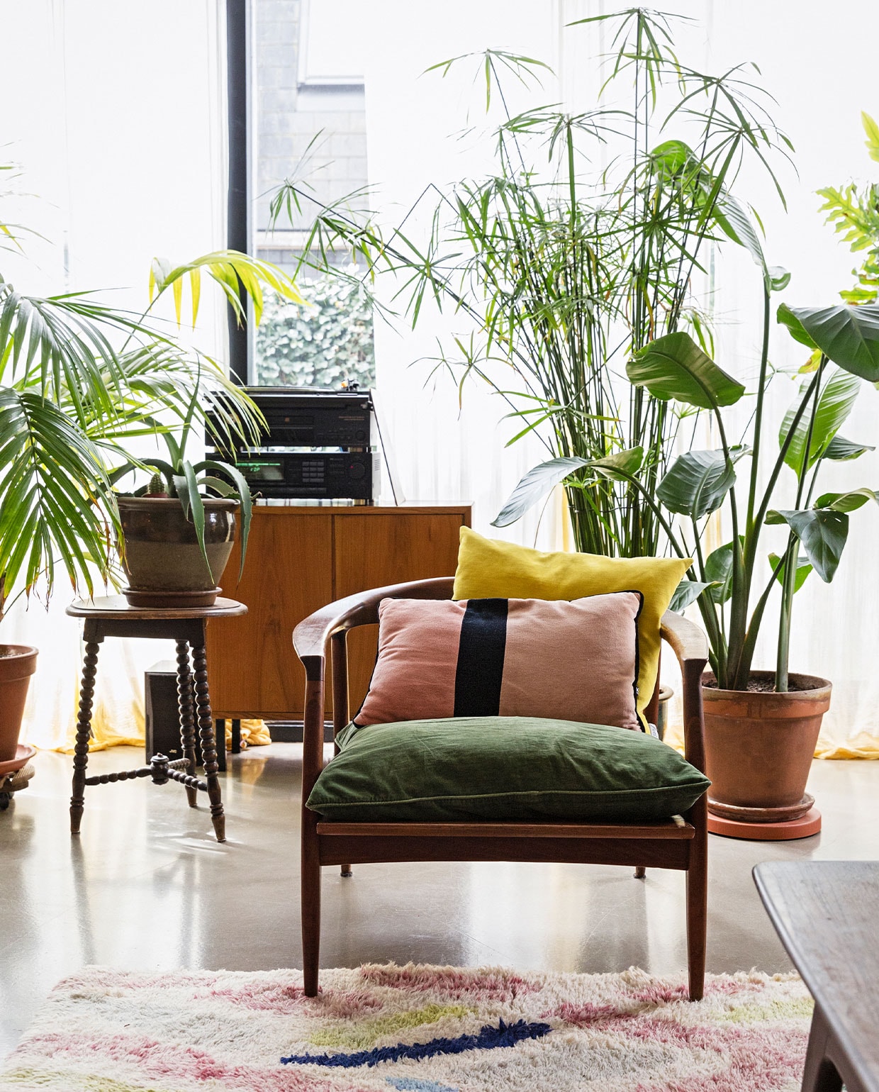 Gordijnen zelfgemaakt en zelf geverfd, stoel vintage vondst rommelmarkt New York, roze kussen HKliving, gele kussen Raaf, sierkussens, kast DasGaaf, kruk Marktplaats, plantenpotten verschillende tuincentra, planten Sprinklr Planten en Tuincentrum Het Oosten, kleed Living Maroc, salontafel Louis van Teeffelen.
