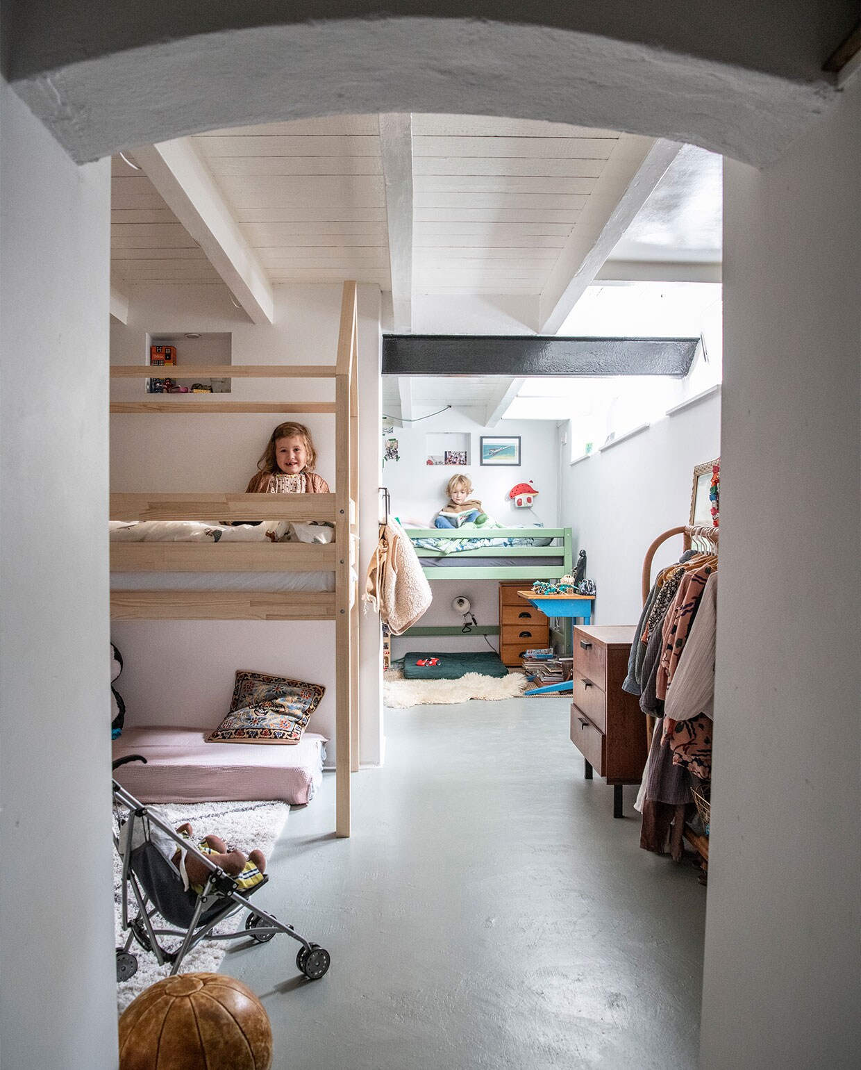 Ondervloer geïsoleerd met garageverf. Blankhouten bed Petit Puk, matras uit ledikant bekleed met hydrofiele doek Yumi Baby, kussen souvenir Turkije, vloerkleed H&amp;M Home, leren bal vintage. Groen bed Hoppekids, paddenstoelenlamp door opa en oma gemaakt, schapenvacht Ikea, ladekast erfstuk, bureau op straat gevonden. Kledingrek Zara Home, jaren 50 ladekast Marktplaats.