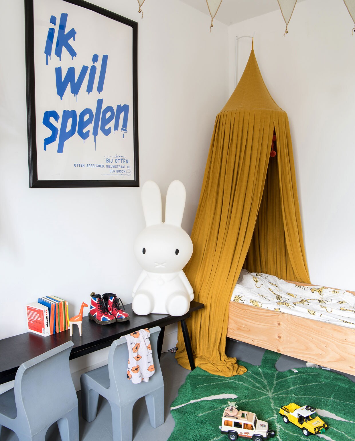 Poster Studio Boot, klamboehemel Play at Slaep, bed Piet Hein Eek, dekbedovertrekset Wehkamp, vloerkleed Lorena Canals, vlaggenlijn Numero 74, stoelen Richard Hutten, schoenen Dr. Martens. T-shirt CarlijnQ, giraffe Kid O, jeep Playmobil, gele jeep van Patrick van vroeger, Nijntje-lamp Mr Maria.