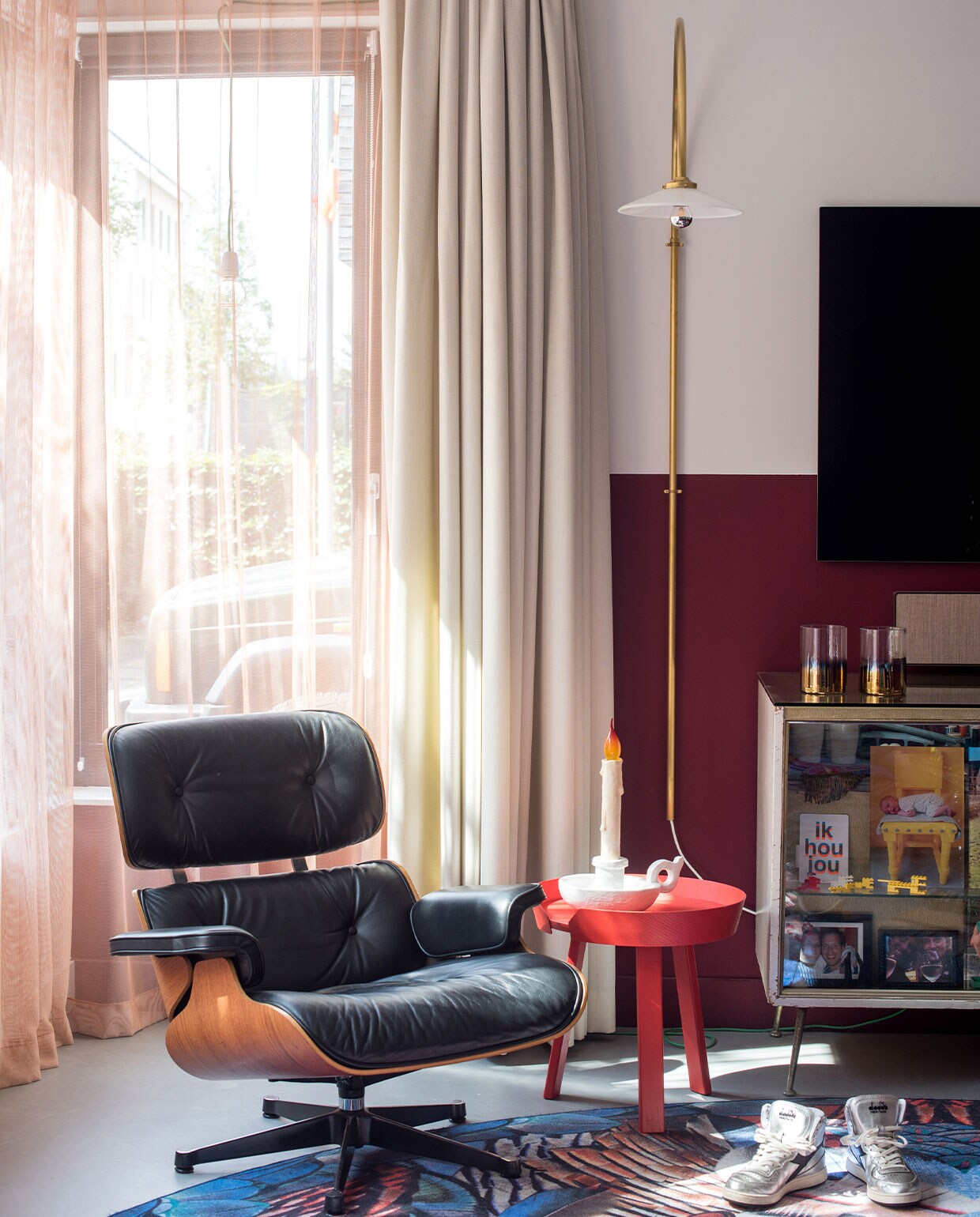 Muurverf onderkant wand Markant van Histor. Stoel Eames Lounge Chair Vitra, vloerkleed Moooi Carpets, bijzettafel Muuto, lamp Muller van Severen, ledlamp Bugia, tafelkaars Seletti, oude toonbank uit juwelierswinkel, in toonbak onder andere privéfoto’s, kaarsenhouders Pols Potten. Schoenen Diadora Heritage. Overgordijnen gemaakt door stoffeerder, vitrage van Kvadrat-stof.