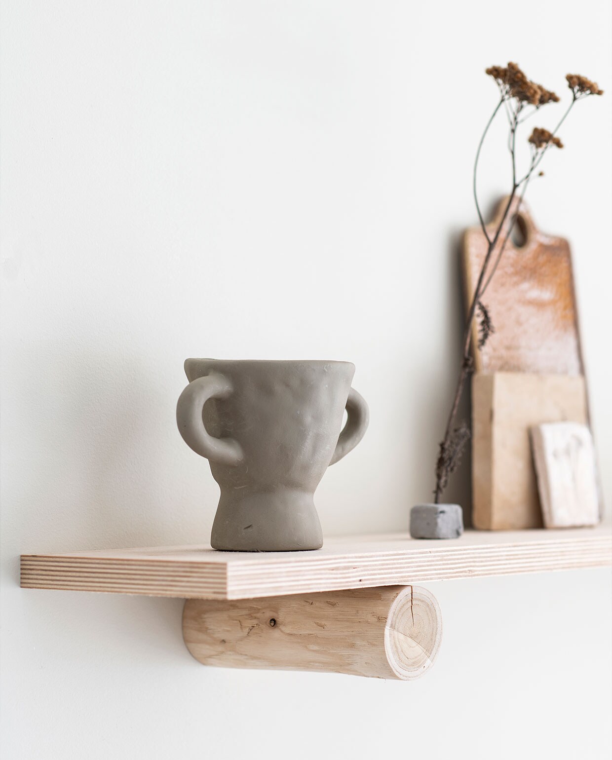 Grijs geschilderde vaas Søstrene Grene. Keramieken broodplank Sûr Atelier.