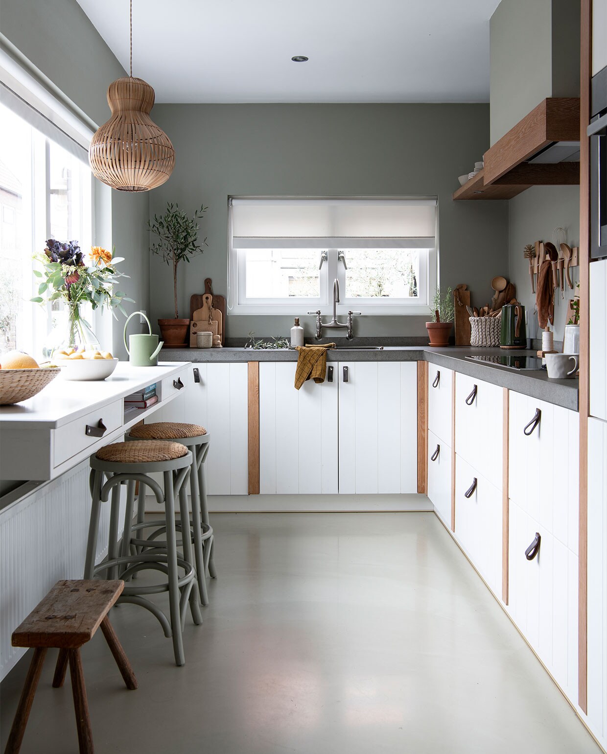 Keuken op maat gemaakt door een bedrijf dat niet meer bestaat. Kraan herkomst onbekend. Bar ontworpen door Stephanie, uitgevoerd door een timmerman. Groen geverfde barstoelen Loods 5. Krukje rommelmarkt. Muurverf Mild Tundra van Flexa Pure. Lepelrek DIY-idee van Janneke Peeters, dat Stephanie aanpaste. Geruite theedoek Villa Augustus. Bak H&amp;M Home. Broodplanken kringloopwinkel. Gieter Sissy-Boy Homeland.