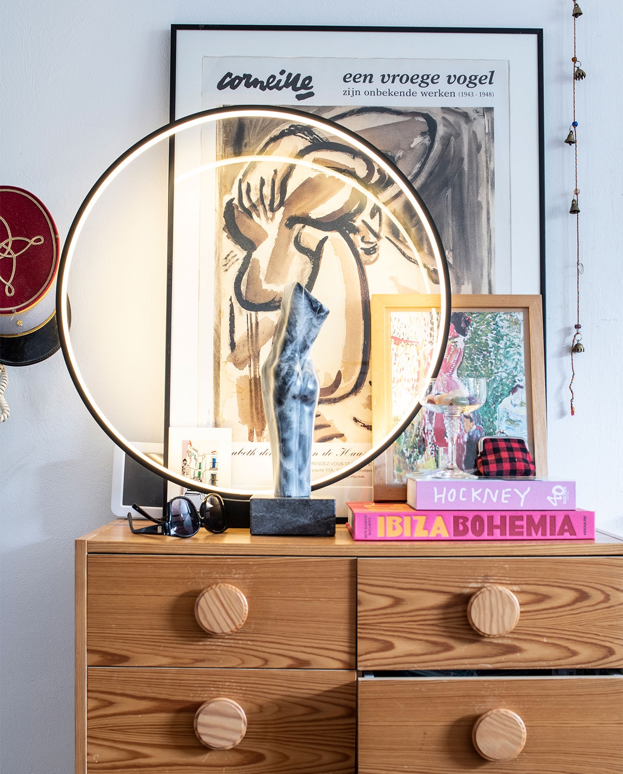 Ladekast Rataplan. Ronde lamp HKliving. Corneille poster Noordermarkt. Beeld handgemaakt door Kims moeder. Glas vlooienmarkt Parijs. Slinger met bellen souvenir uit Marokko.