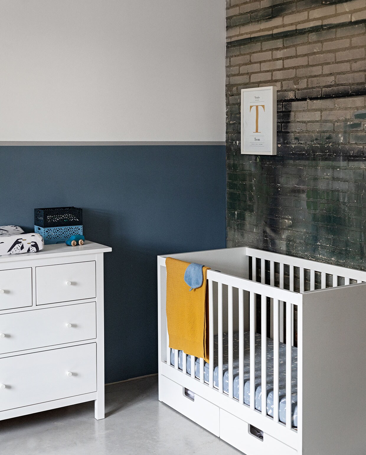Commode en ledikant Ikea. Bakstenen muur met verfresten fabriek. Muurverf Real Indigo en Mild Marble van Flexa. Speelgoedauto Grimm. Bakjes Hema. Overig onbekend.