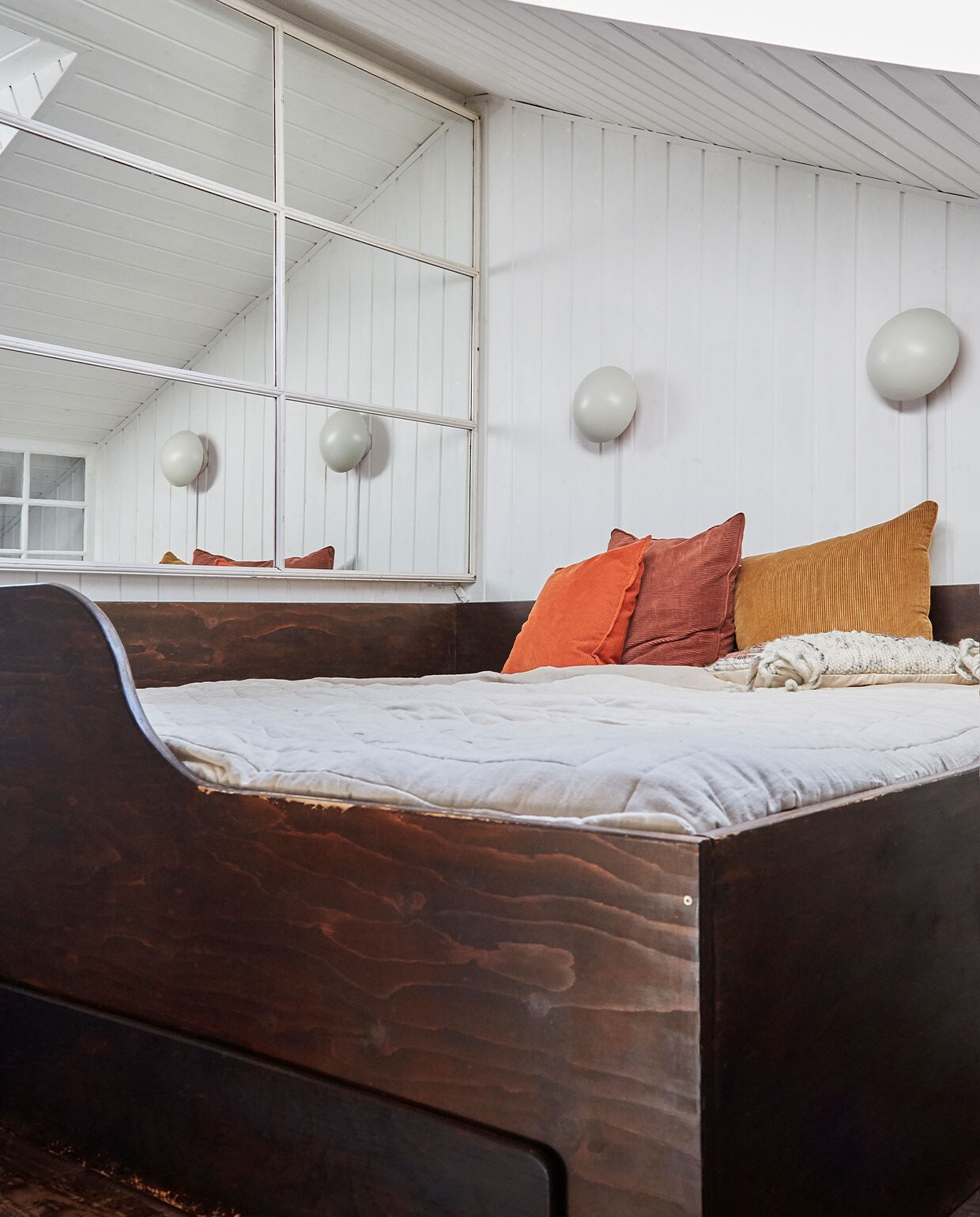 Multiplex bed zelfgebouwd. Oude spiegel tweedehands. Wandlampen Louis Poulsen. Kussens onbekend.