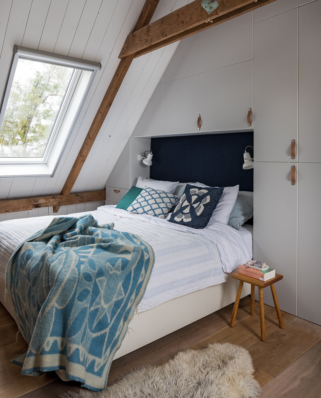 Kasten Ikea. Lampen Anglepoise. Vintage deken AaBe, lichtblauwe sprei Sissy-Boy Homeland. Herkomst donkerblauw en wit kussen onbekend. Groene kussens en melkkruk Sip &amp; Clara Pop-up Store. Schapenvacht Van Buren Bolsward. De mobile is zelfgemaakt.