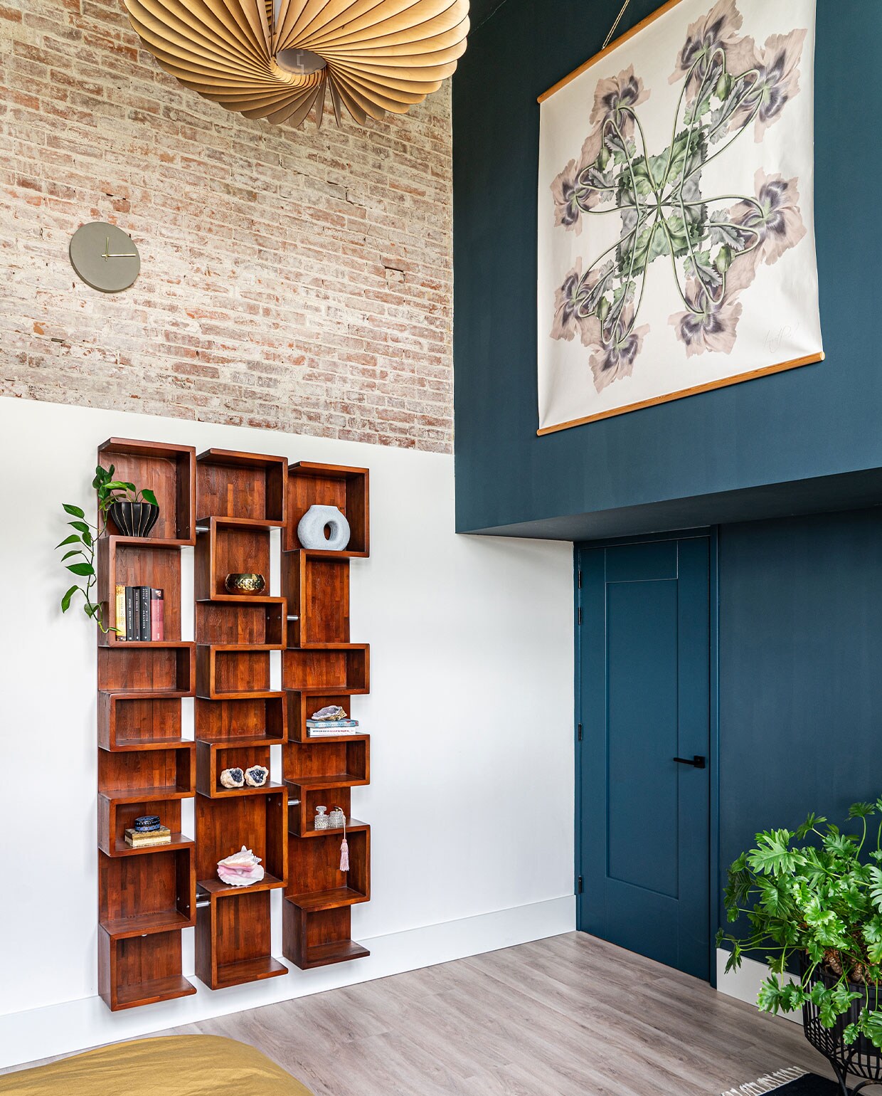 Muurverf Steel Blue van Pure &amp; Original. Kast vintage, kunstwerk Hanneke van de Pol, kleed Ferm Living, lamp Werp, plantenstandaard Urban Nature Culture. In de kast blauwe vaas van HKliving, gouden kom van Broste Copenhagen, overig onbekend.
