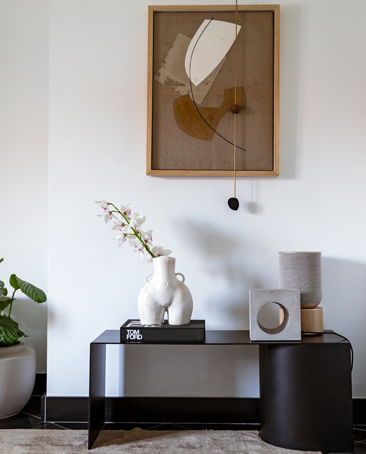 Vloerkleed Benuta. Plantenpot Serax. Bank Ferm Living. Boek Tom Ford. Vaas Anissa Kermiche. Lamp Serax. Box Bang &amp; Olufsen. Kunstwerk Atelier de Rijk.