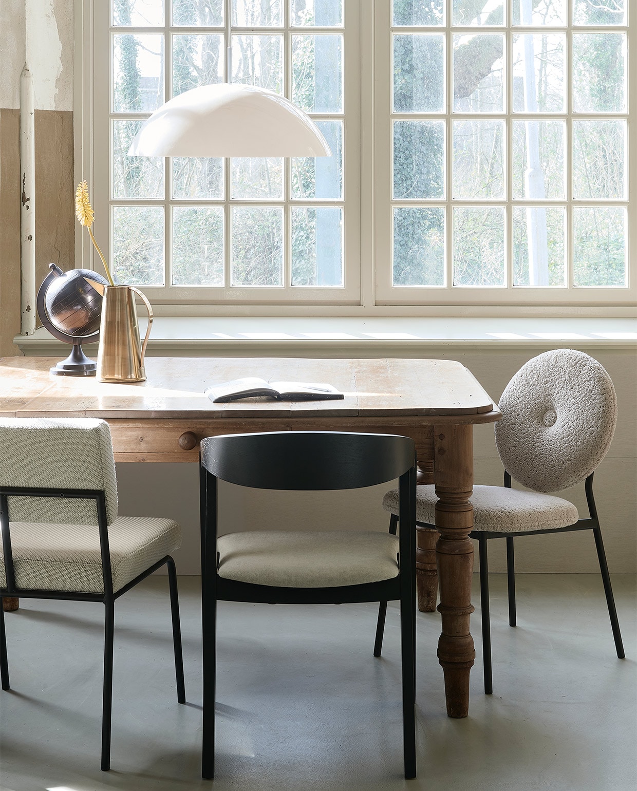 Grenenhouten tafel, 180x90x80 cm (lxbxh) prijs op aanvraag (vandijkenko.nl). Bouclé stoel Mist € 259,- (zuiver.com). Zwart gebeitste stoel Edske € 229,-(demachinekamer.nl). Stoel Monday, metalen frame € 299,- (festamsterdam.com). Acryl hanglamp Cupola € 170,- (hkliving.nl). Koperen kan Kassan € 49,50, globe Miles vanaf € 39,- (dutchbone.com).