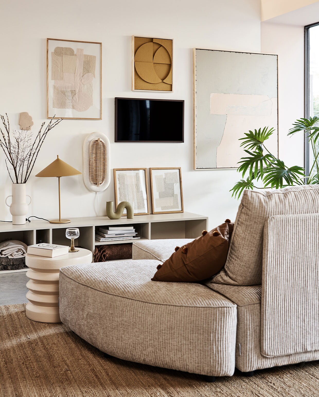 Televisie The Frame, 32 inch € 429,-, verwisselbare walnoothouten lijst The Frame € 129,- (samsung). Kast in kleur Skimming Stone 241 van Farrow &amp; Ball, prijs op aanvraag (combitex). Handgemaakte ovale wandlamp Aplique Ovalado € 299,-(lanena-home.com). Sofa Hunter uit diverse losse onderdelen: poef € 419,-, element met rug € 1009,-, element zonder rug € 419,- (zuiver). Bruin kussen met pompons van Ferm Living € 29,95,-, roze stoneware bijzettafel van HKliving € 159,- (vtwonen.be). Vaas Twisted in mat olijfgroen € 34,95, hennep vloerkleed 180×280 cm € 395,-, olijf/roze-kleurig abstract kunstwerk (rechts) 100×120 cm (bxh) € 549,-, okergeel kunstwerk boven tv van 43x4x53 cm (bxdxh) € 329,-, taupekleurig wandornament Face€ 37,95, crèmekleurige bijzettafel, 38×36 cm (Øxh), prijs op aanvraag, wijnglas met groene voet € 9,95, okergele lamp Triangel € 149,-(hkliving). Stoffen kunstwerk in eikenhouten lijst € 89,-, kunst­werken in lijst op kast, per stuk € 69,-(sur-atelier). Bruine en beige katoenen plaids in dressoir 130×170 cm, per stuk € 45,99 (zarahome.com). Donkerbruine plaid rechts in dressoir, 130×170 cm (bxl) € 65,- (maisonnl.com). Overig privébezit.