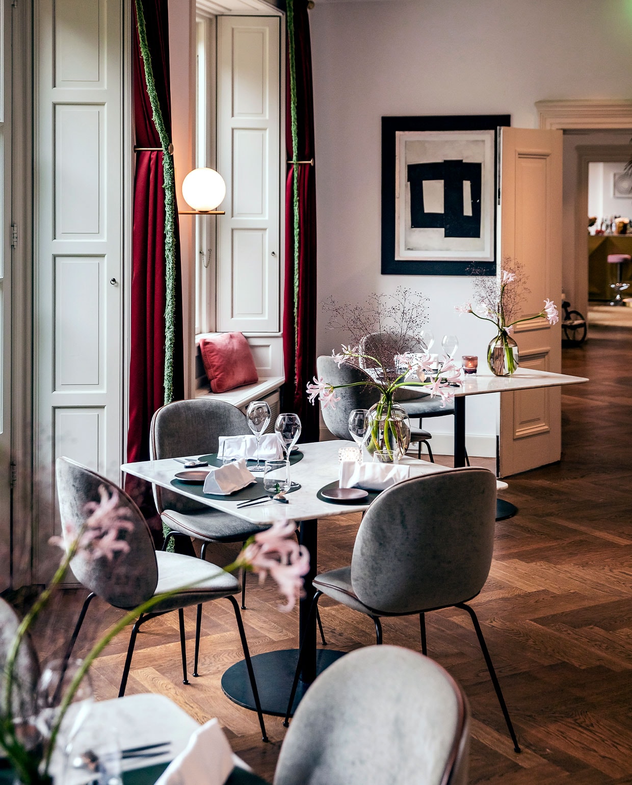 Beetle chairs van GamFratesi voor Gubi, kunstwerk van San Ming. Wandlamp van geborsteld messing van Michael Anastassiades voor Flos.