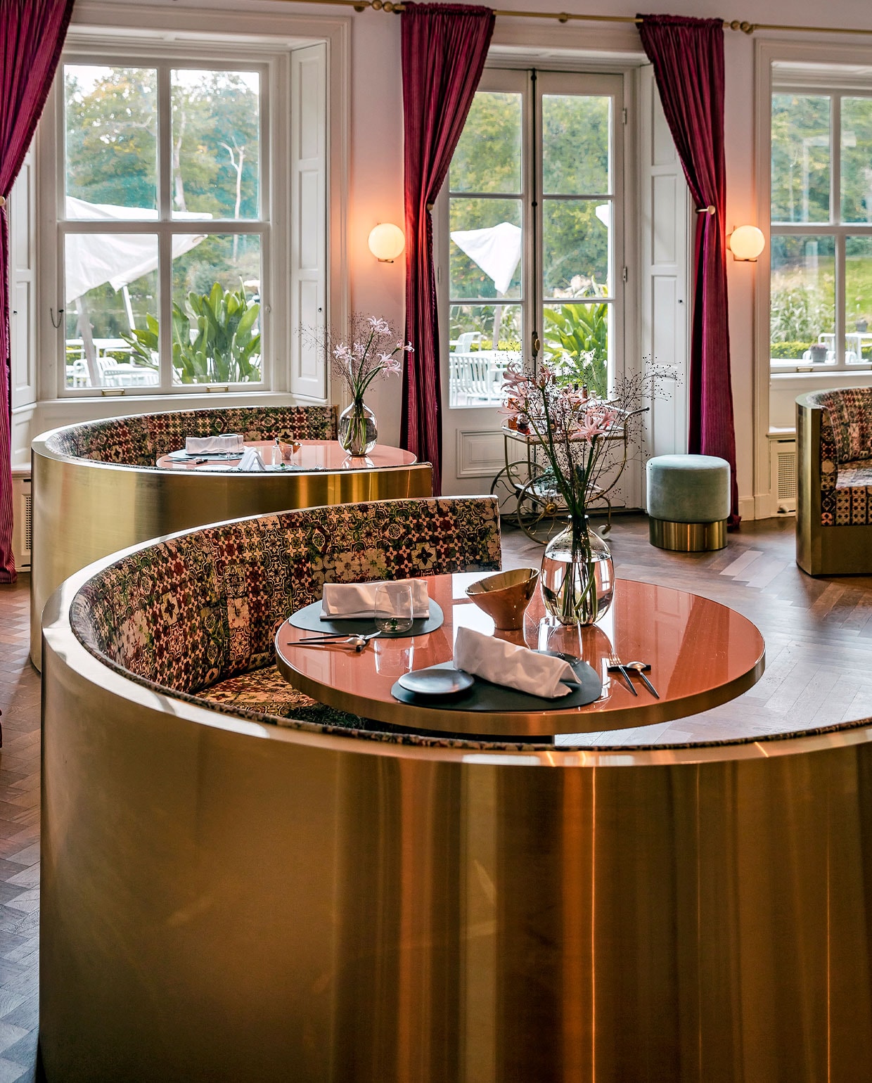 De gebogen messing banken in De Parc-zaal, onderdeel van restaurant Voltaire, zijn op maat gemaakt en geven een gevoel van intimiteit en geborgenheid. Interieurontwerper Judith van Mourik liet ze bekleden met de stof Azulejos van Jean Paul Gaultier voor Lelièvre, de motieven zijn gebaseerd op handbeschilderde azulejos, tegels uit Spanje en Portugal.